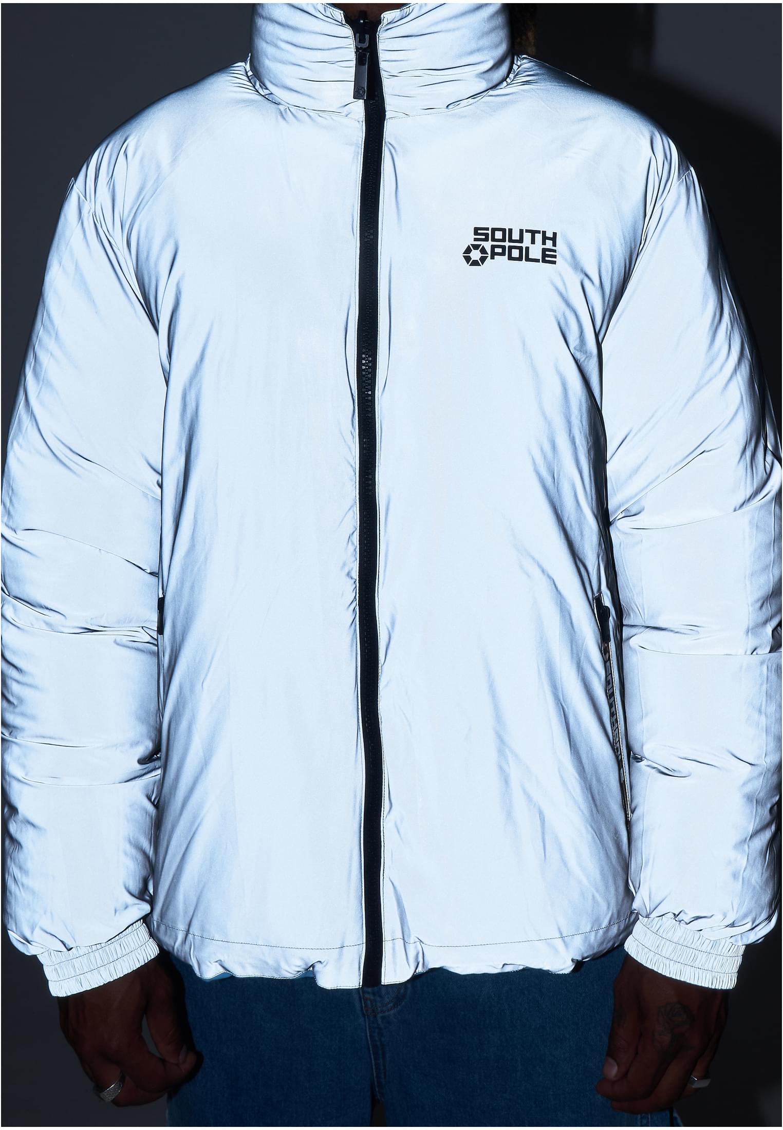 Närbild på framsidan av en ljusgrå, reflekterande pufferjacka från Southpole.
