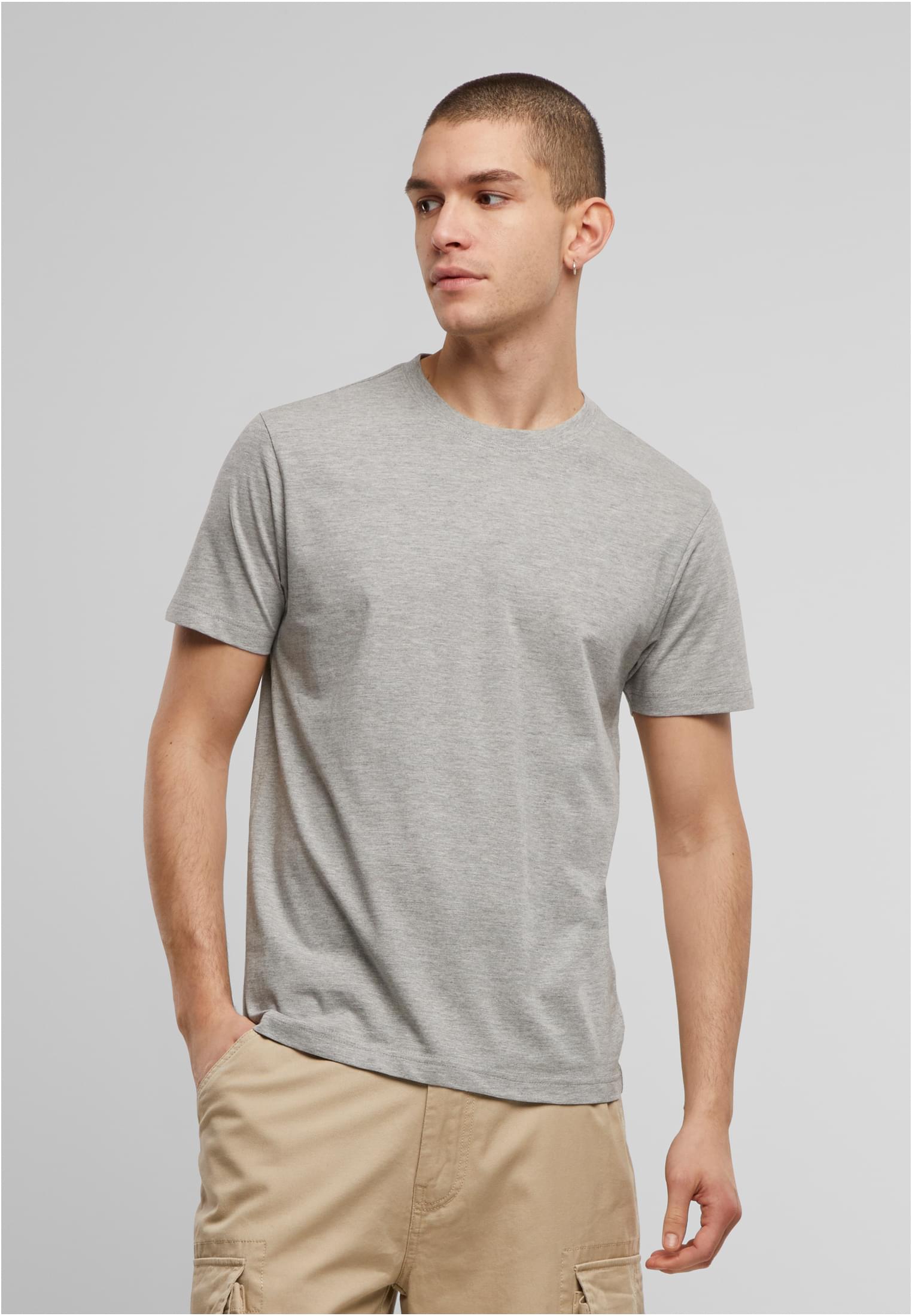 Manlig modell som bär en grå Brandit Premium Shirt och beiga byxor.