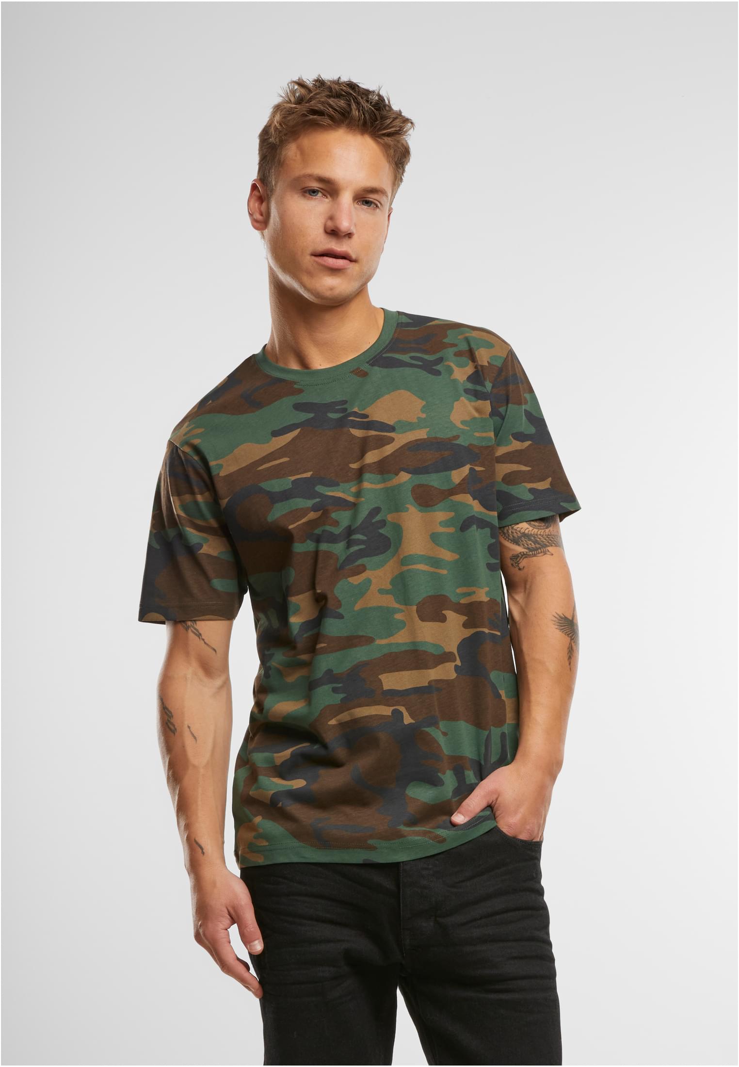 En manlig modell bär en kamouflagemönstrad Brandit Premium Shirt.