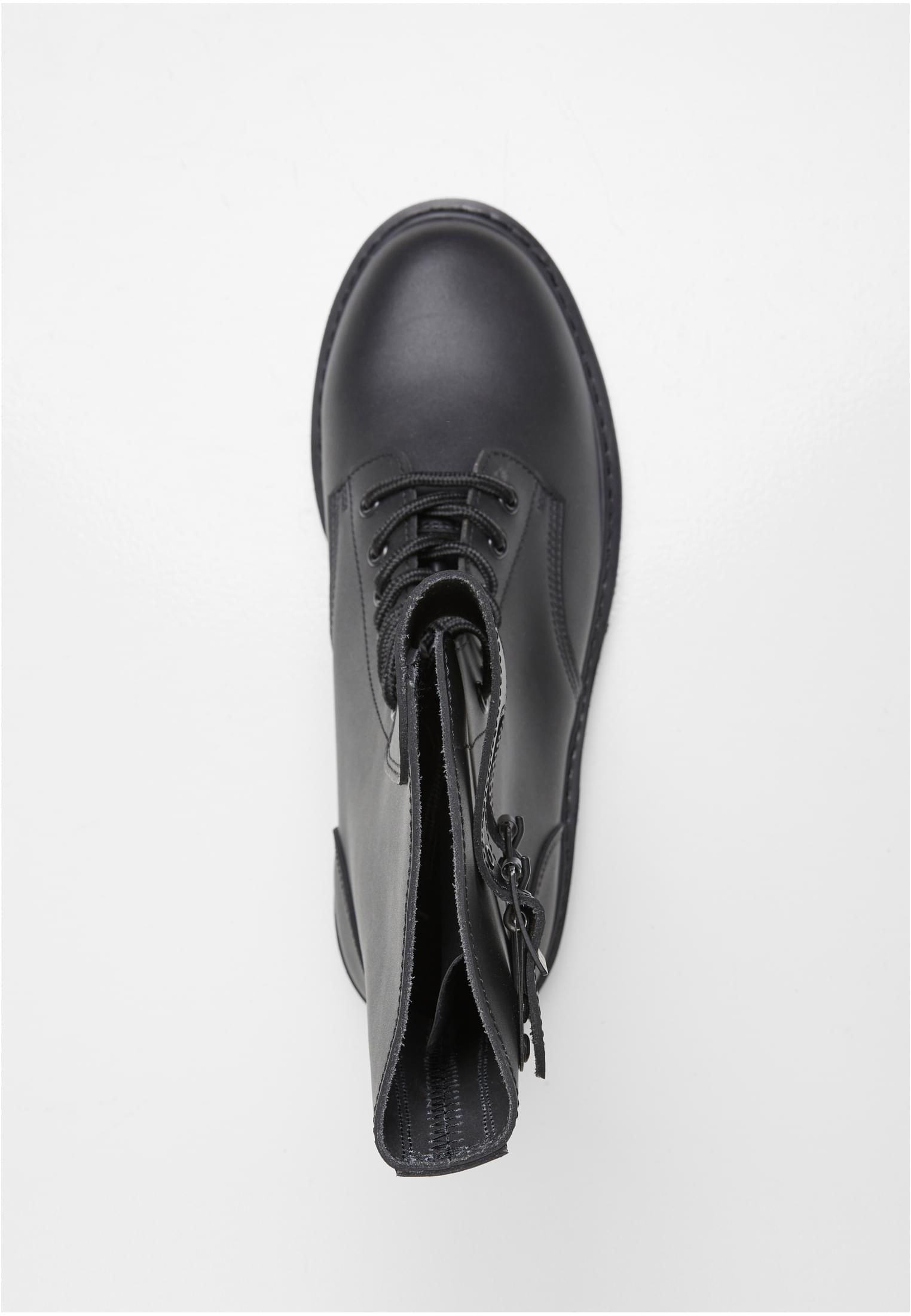 Fågelperspektiv av en svart B French Combat Boot, som visar snörningen och dragkedjan på sidan mot en vit bakgrund.