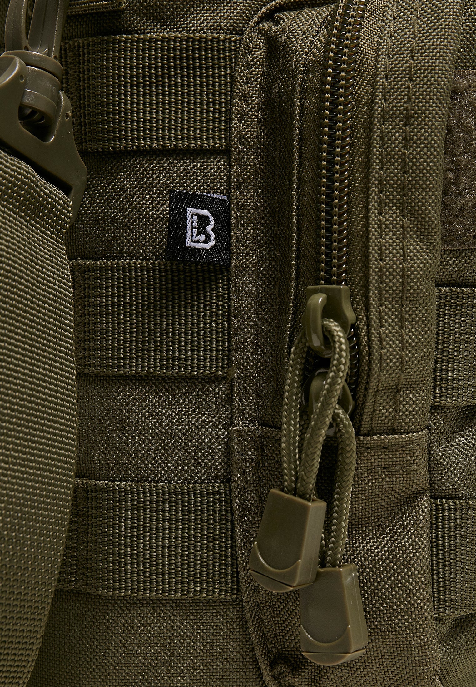 Närbild på B Big Bottle Holder i olivgrönt som visar detaljer som det slitstarka tyget, MOLLE-öglor, dragkedja och Brandit-logotypen.