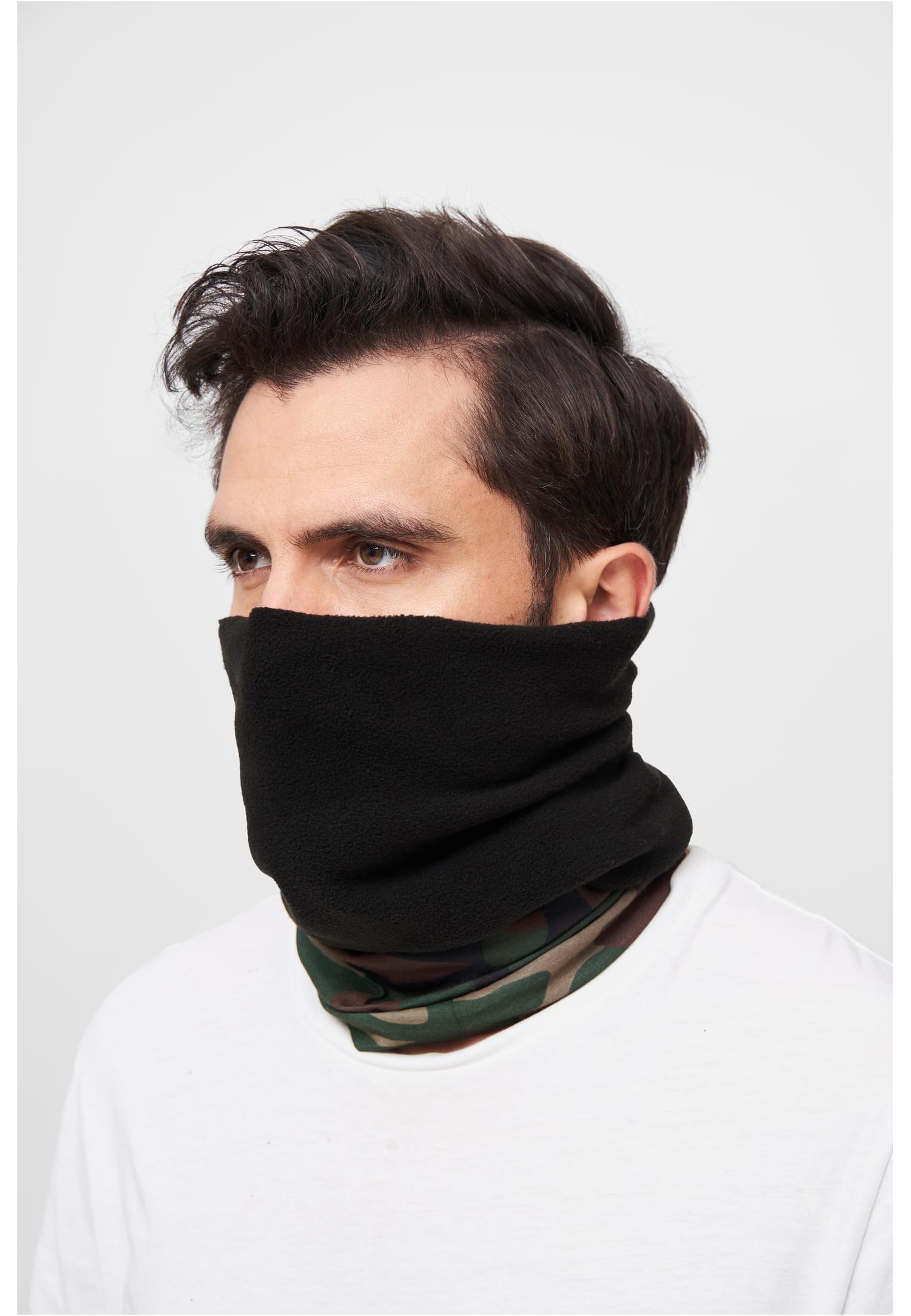 Närbild på en man som bär en svart och kamouflagemönstrad B Halsduk Fleece, uppdragen över nedre delen av ansiktet.