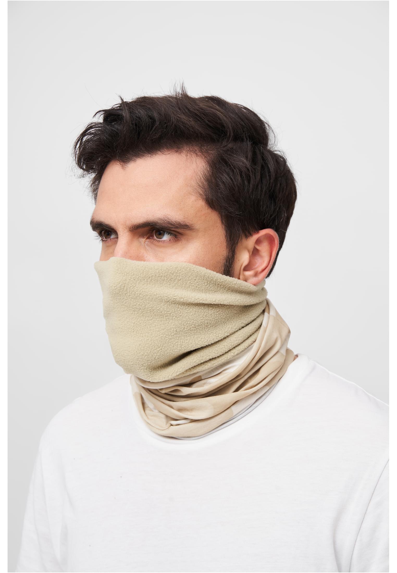 En man bär en beige fleecehalsduk som täcker hans näsa och mun.