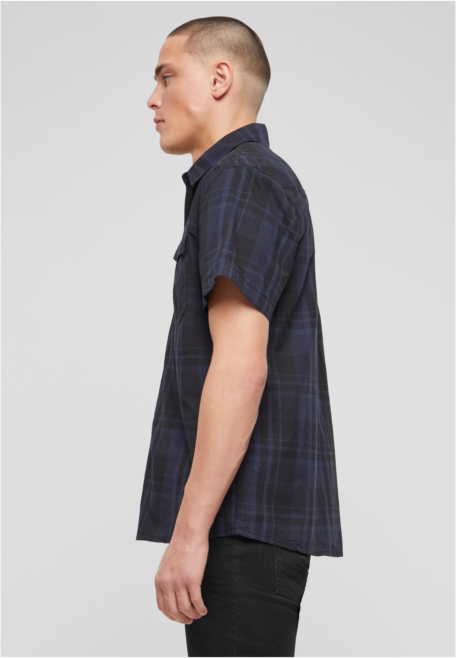 En man sedd från sidan som bär en kortärmad B Roadstar Shirt med mörkblått och svart rutmönster.