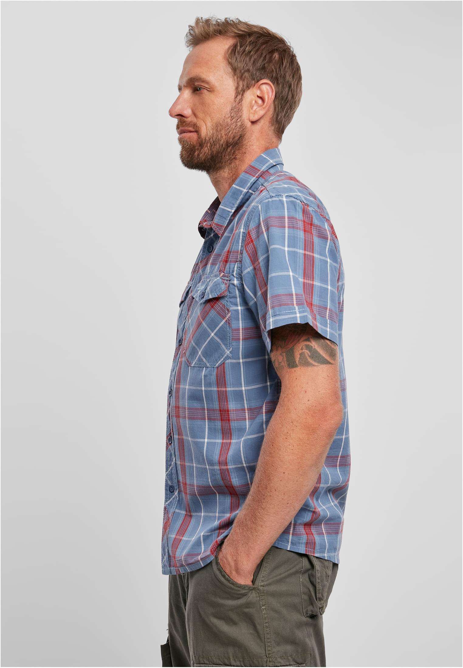 En man, fotograferad i profil, bär den kortärmade, rutiga B Roadstar-skjortan i blått och rött.