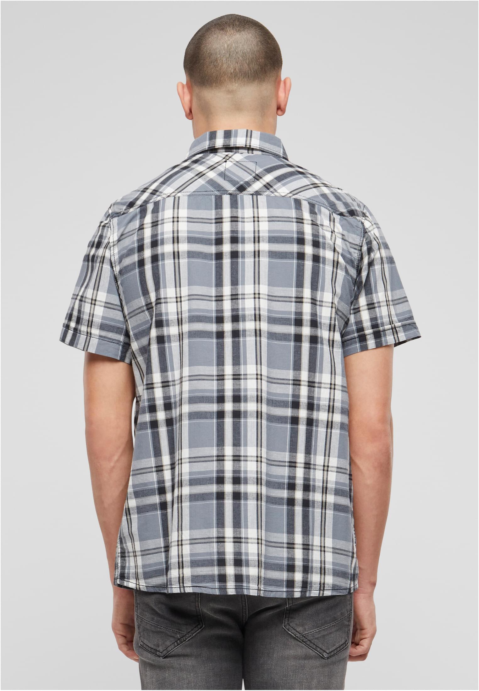 En man visar baksidan av en kortärmad, rutig skjorta i grått, svart och vitt.