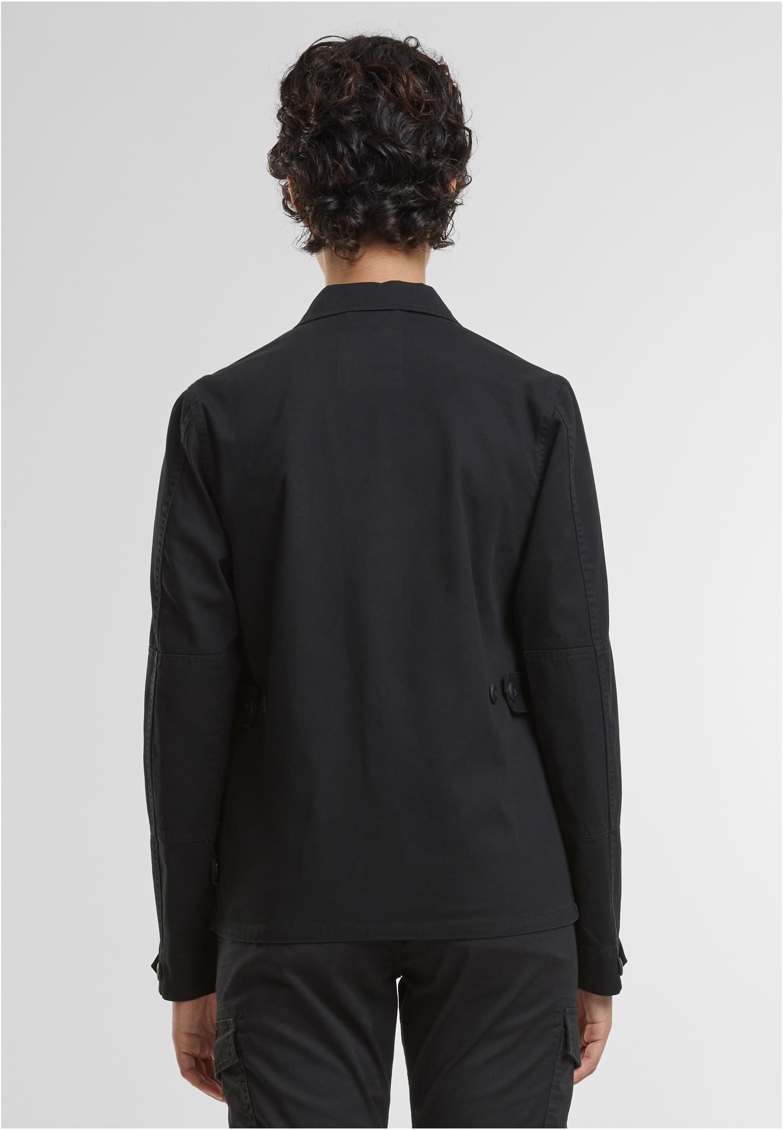 En kvinna visar baksidan av den svarta B BDU Twill-jackan.