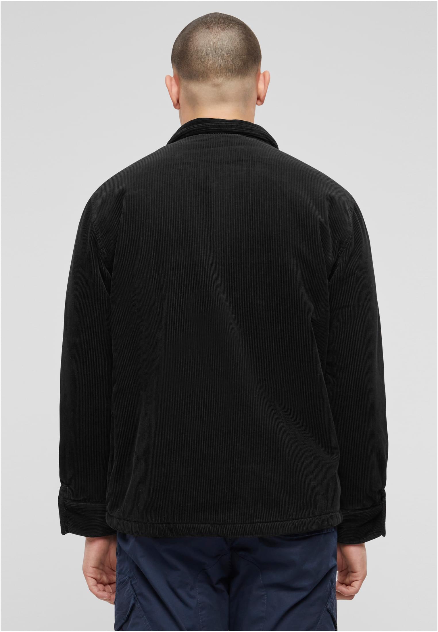 En man visar baksidan av en svart manchesterjacka.