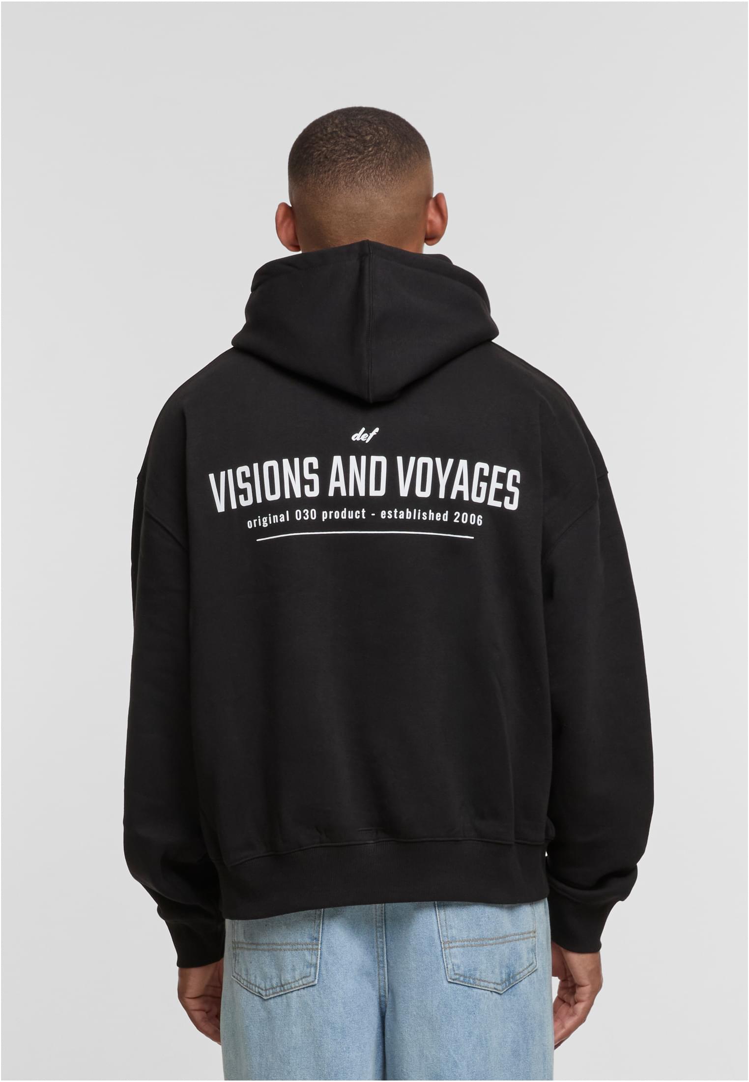 En man visar baksidan av sin svarta DEF VISIONS hoodie med vitt tryck.