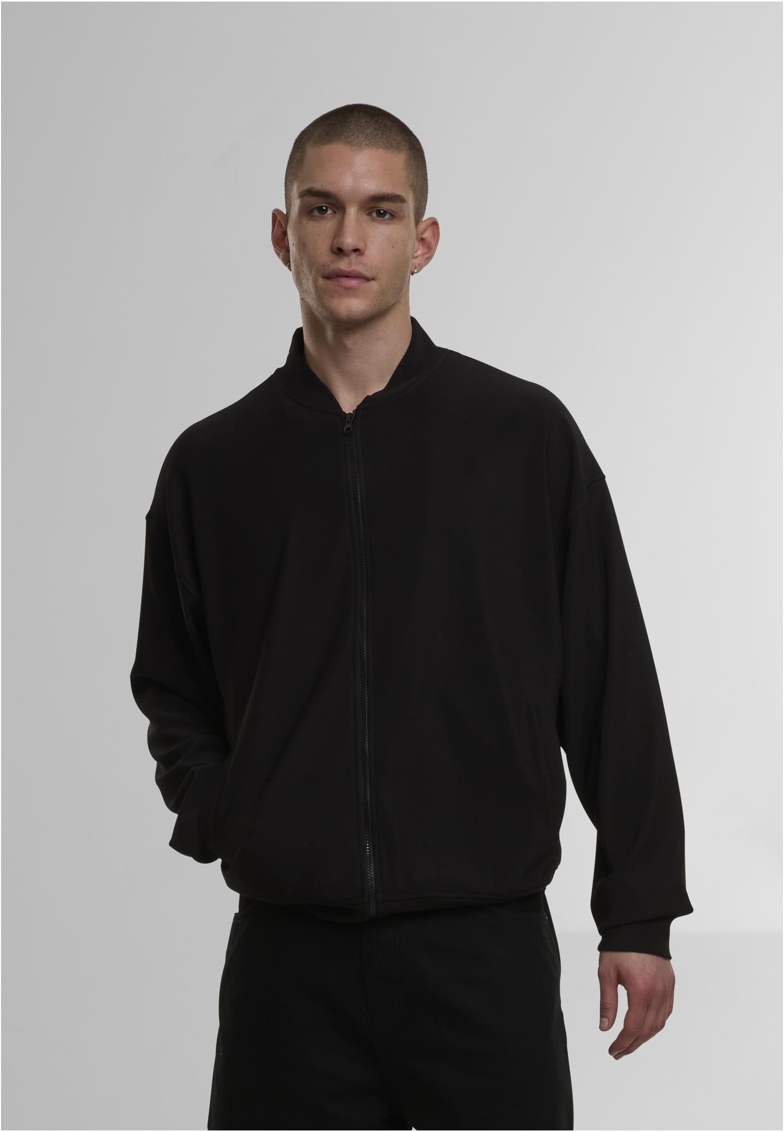 Framsidan av den svarta DEF Milan Jacket, buren av en man som poserar med en hand i fickan.