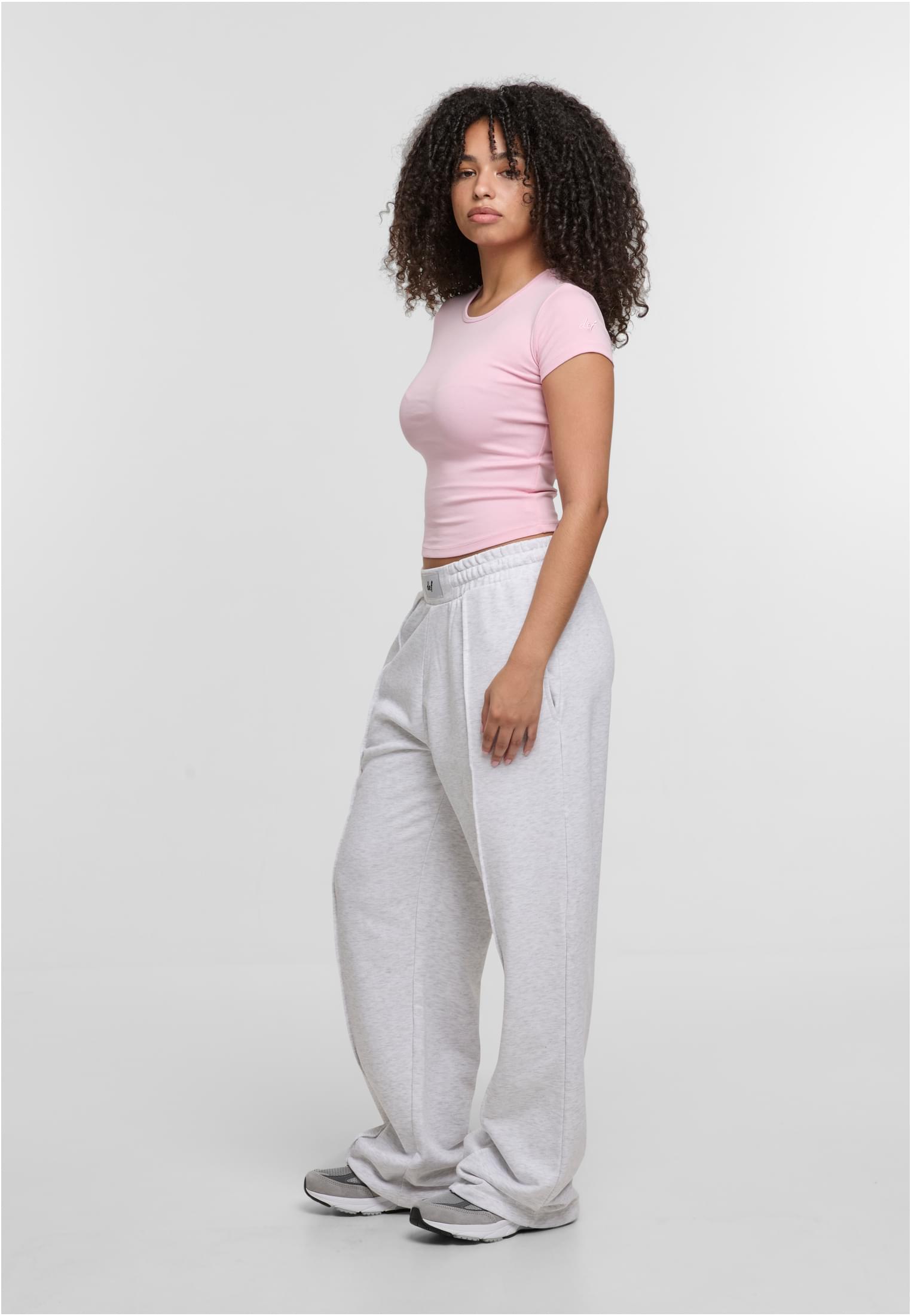 En kvinna visar en rosa DEF Relax T-shirt från sidan.