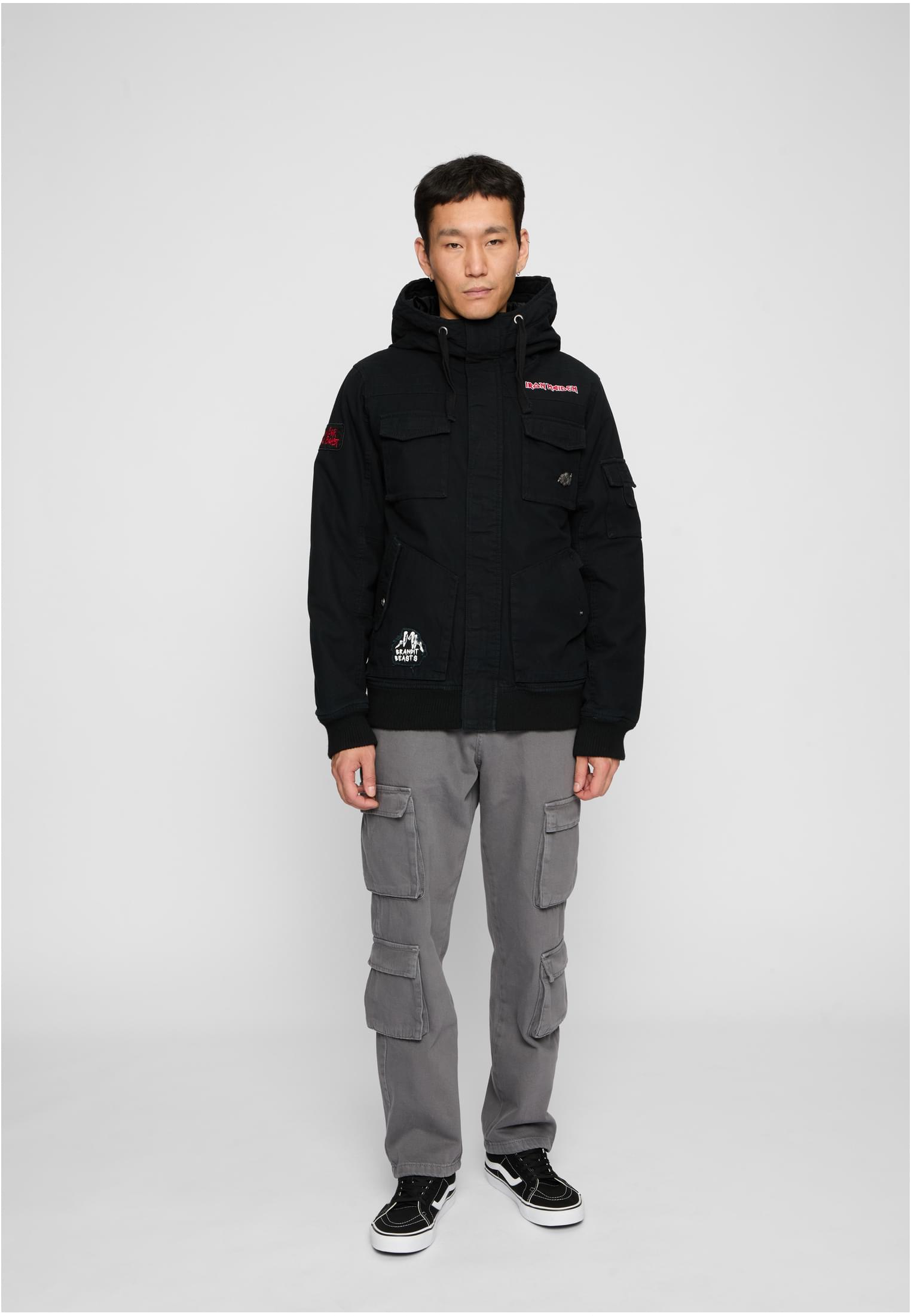 En man visar framsidan av den svarta B IRM Bronx-jackan.