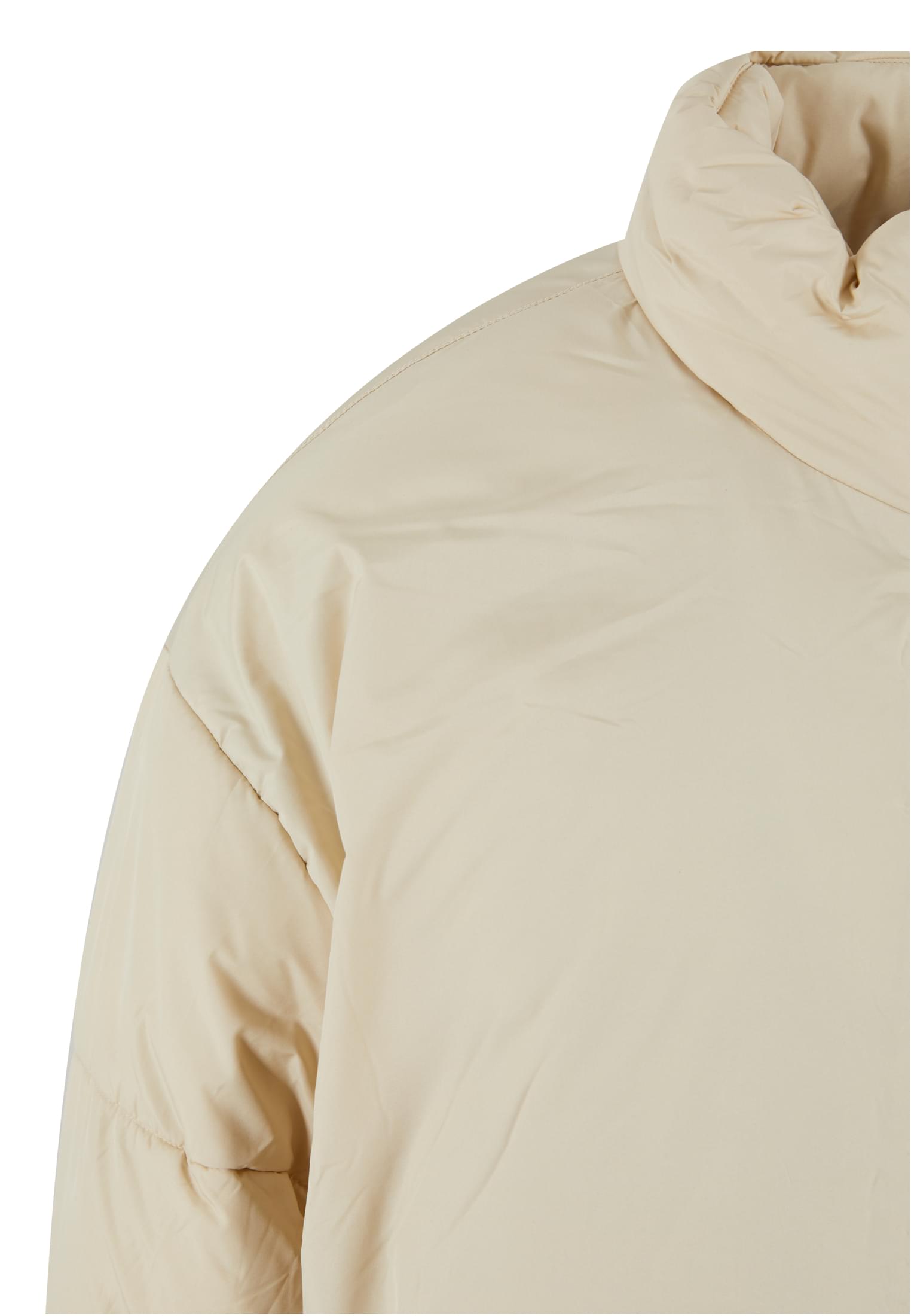 Detaljbild av den beiga MJG Puffer-jackans axel och krage.