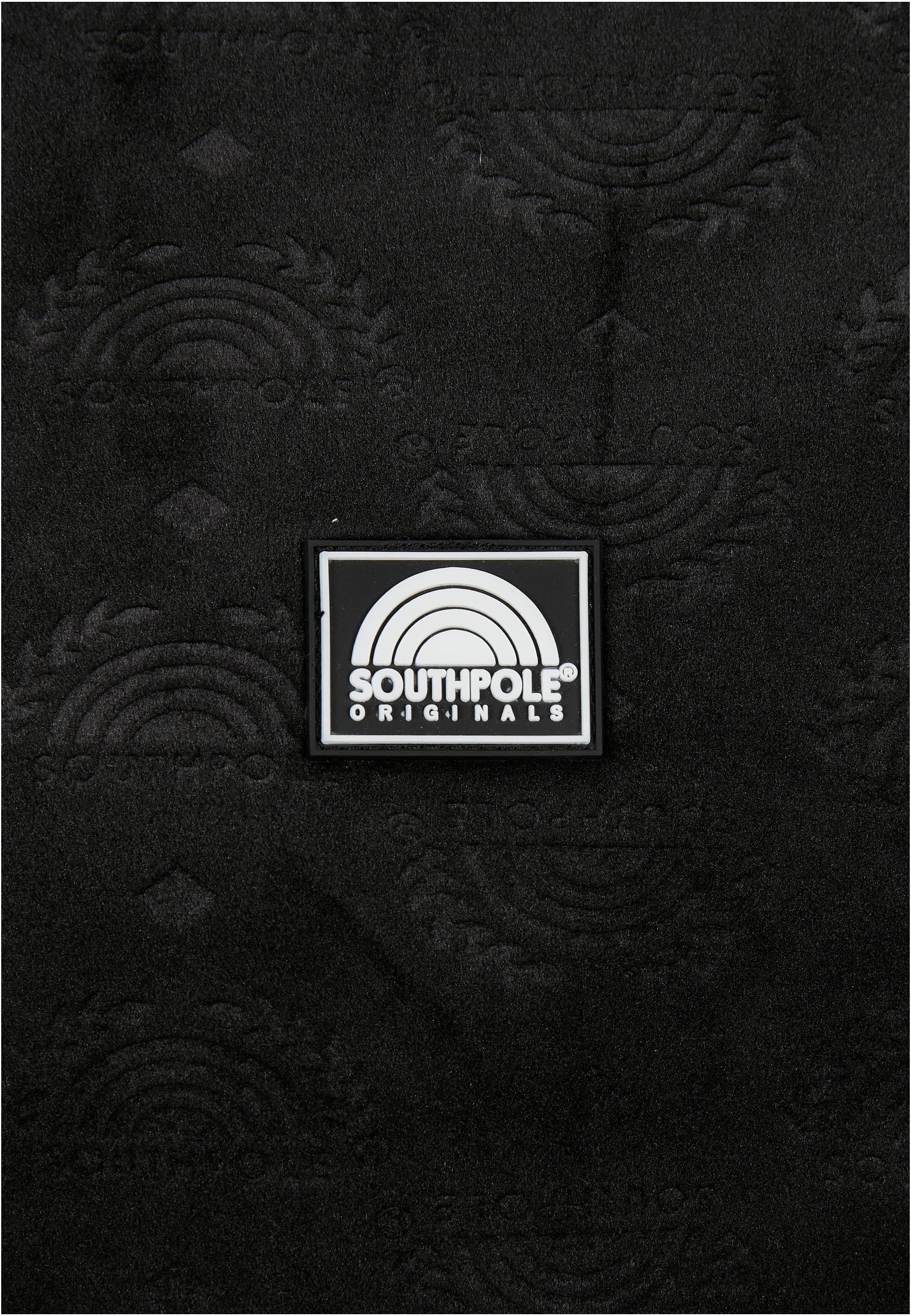 Närbild på det svarta, präglade velourtyget och gummiloggan på Southpole AOP Velour Jacket.