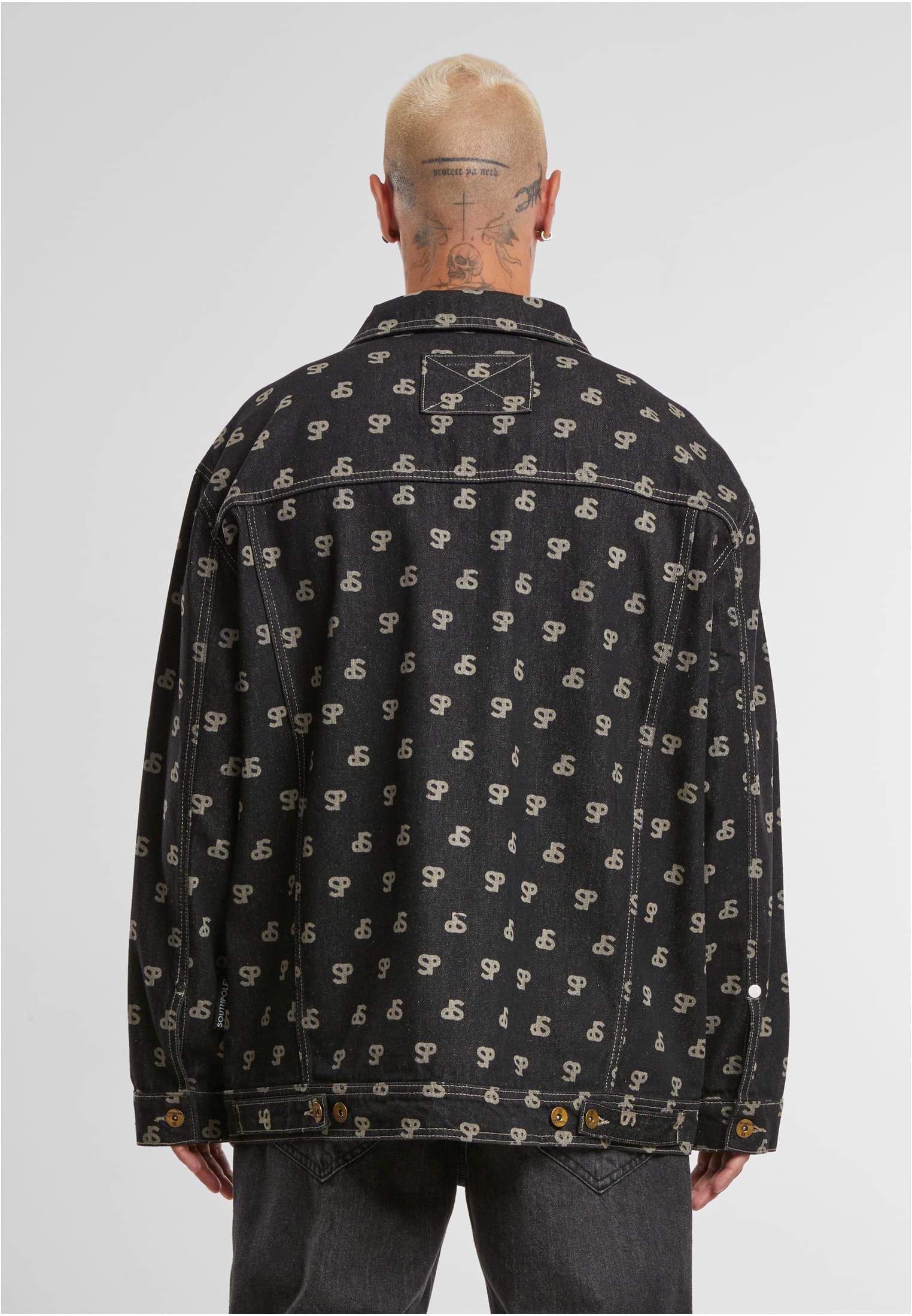 En man visar baksidan av en svart jeansjacka från Southpole med ett heltäckande blekt mönster.