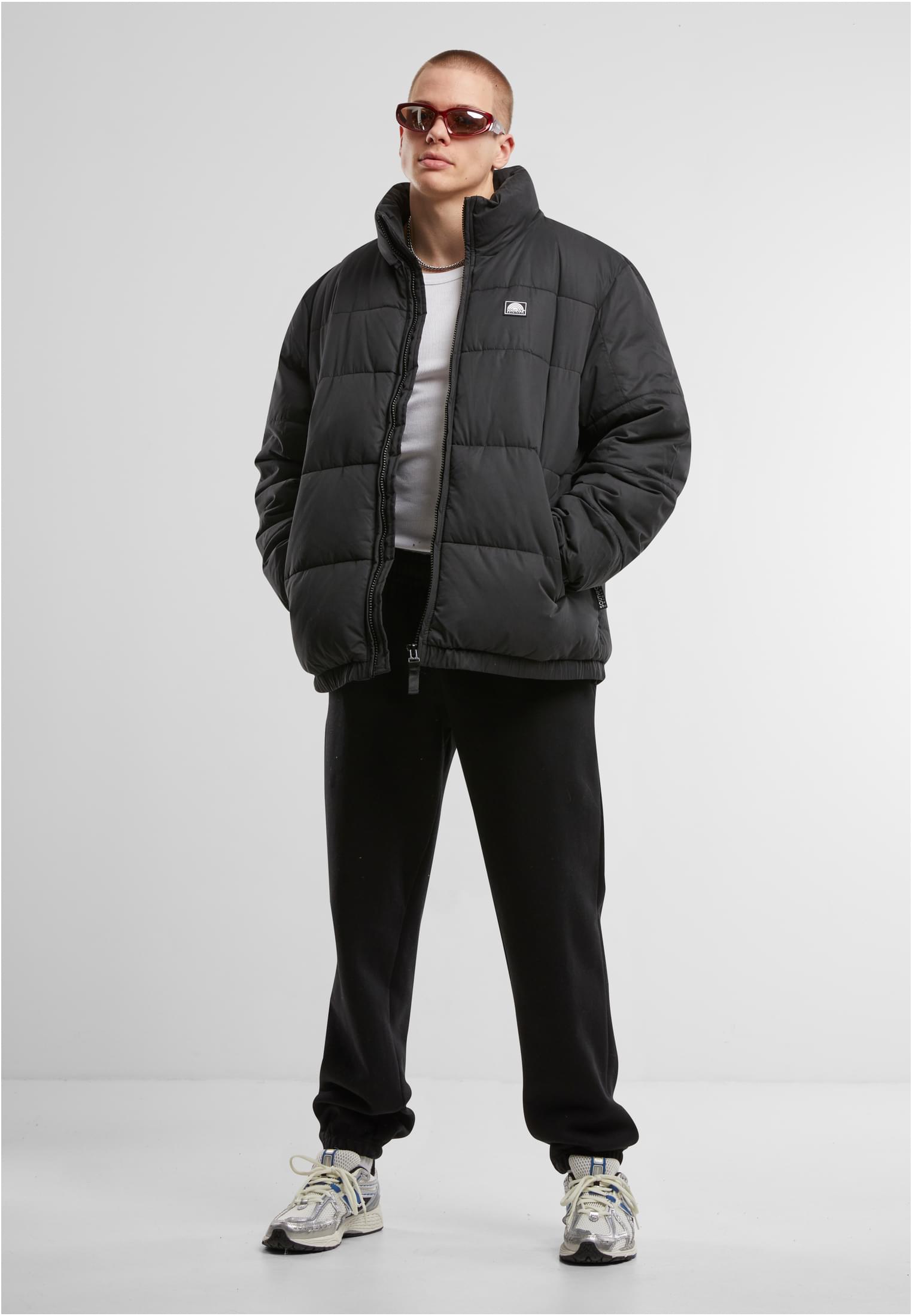 En man visar framsidan av den svarta SP Color Block Puffer Jacket.