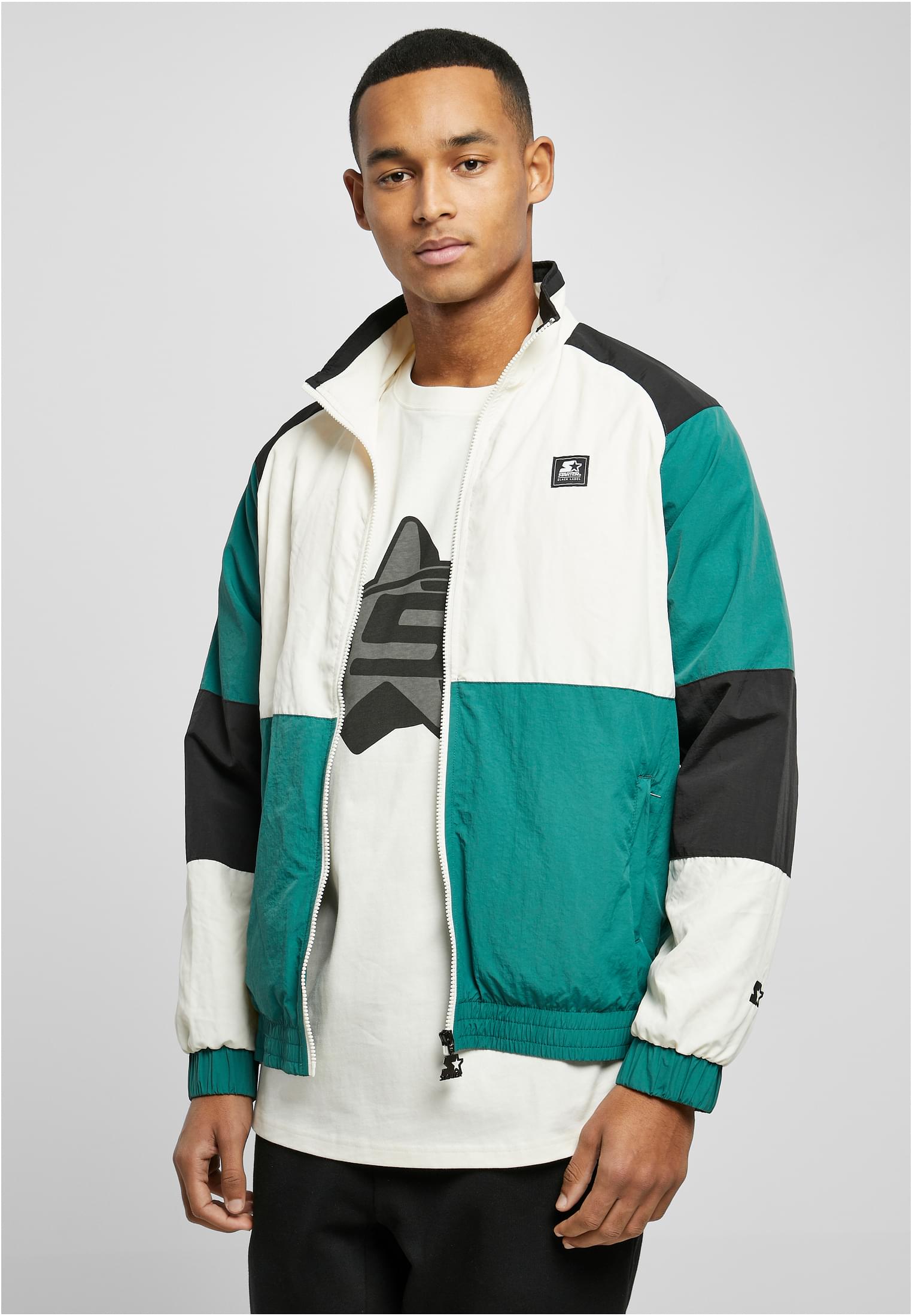 En man bär en öppen SBL Starter Color Block Retro Jacket i färgerna grönt, vitt och svart.