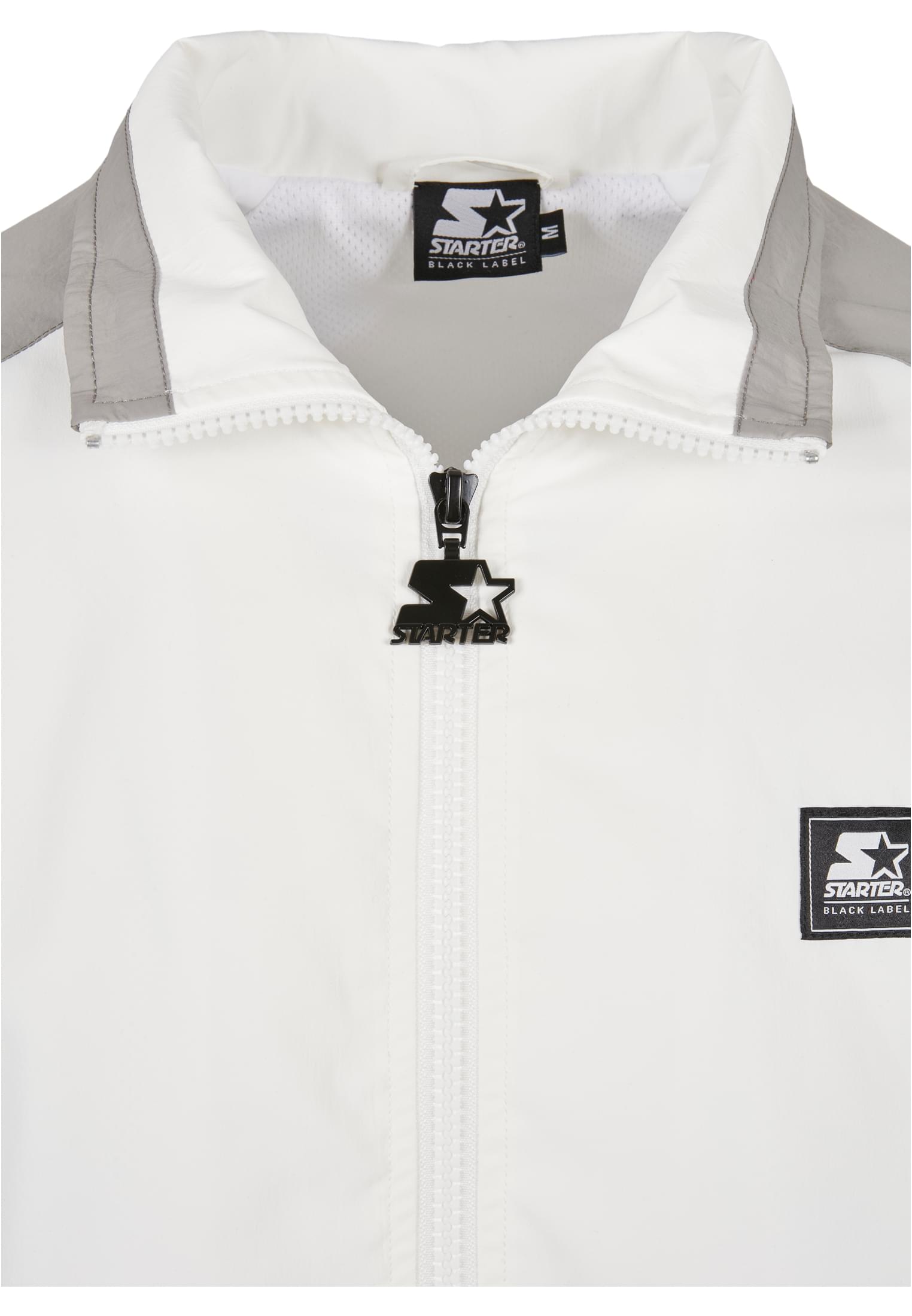 Närbild på kragen och dragkedjan på en vit SBL Starter Color Block Retro Jacket, som visar Starter-logotyperna.