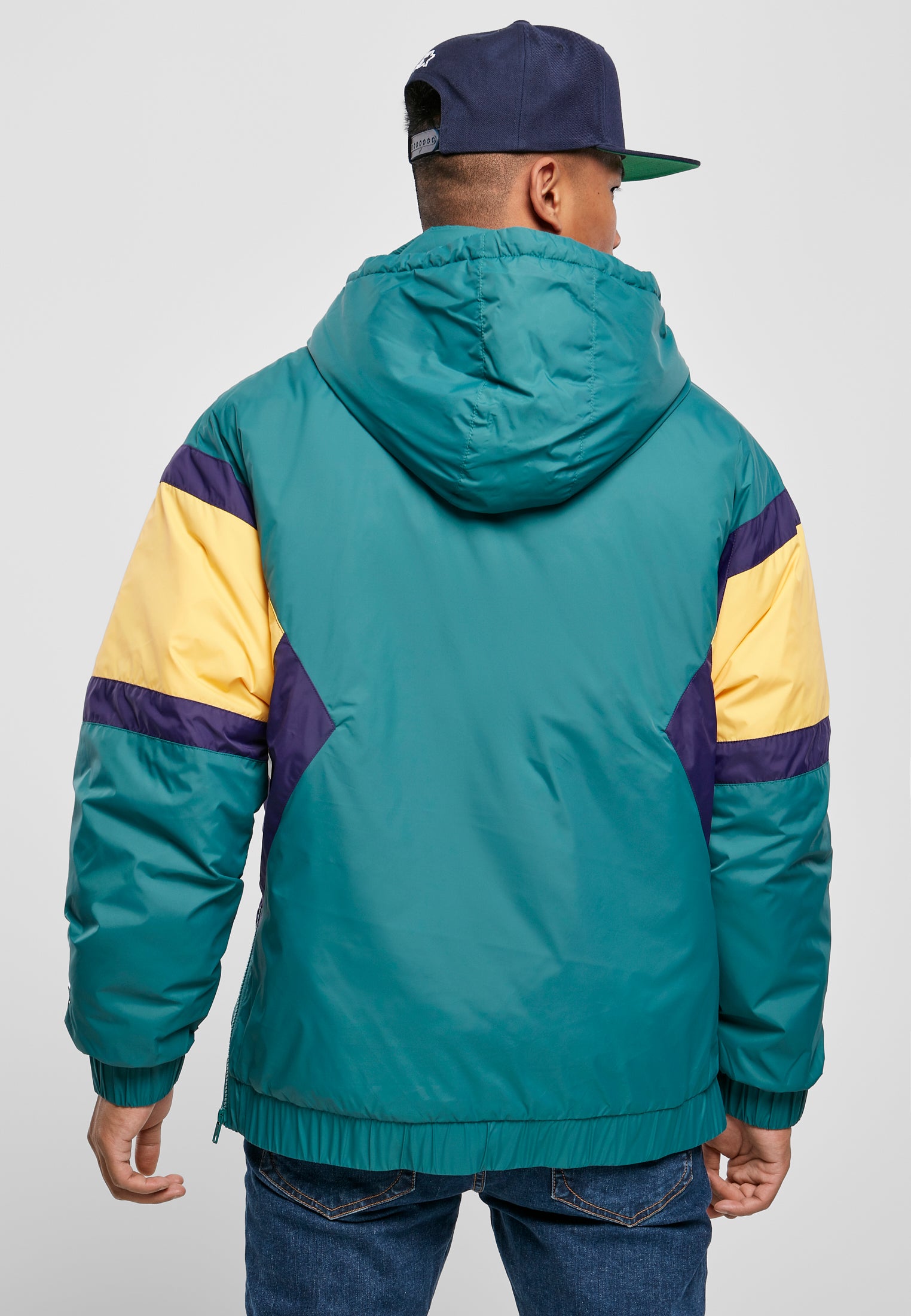 Baksidan av en man som bär SBL Starter Color Block Half Zip Retro Jacka i grönt, gult och lila.