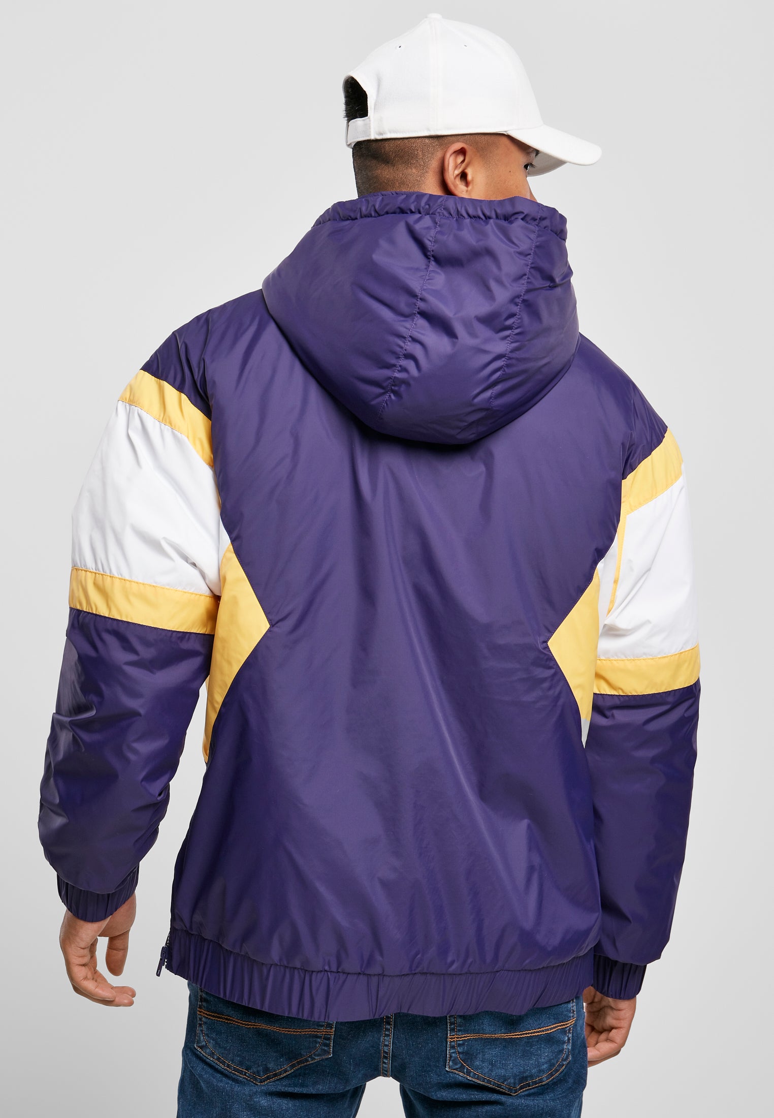 Baksidan av en man som bär en SBL Starter Color Block Half Zip Retro Jacka i lila med gula och vita färgblock.