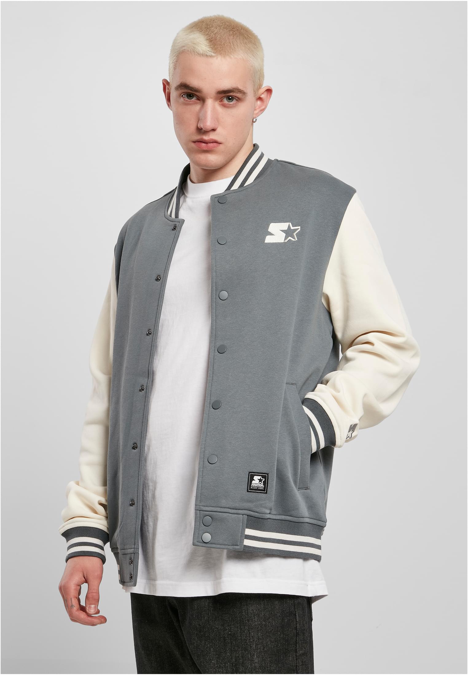 En man visar framsidan av en grå och vit SBL Starter College Fleece Jacket.