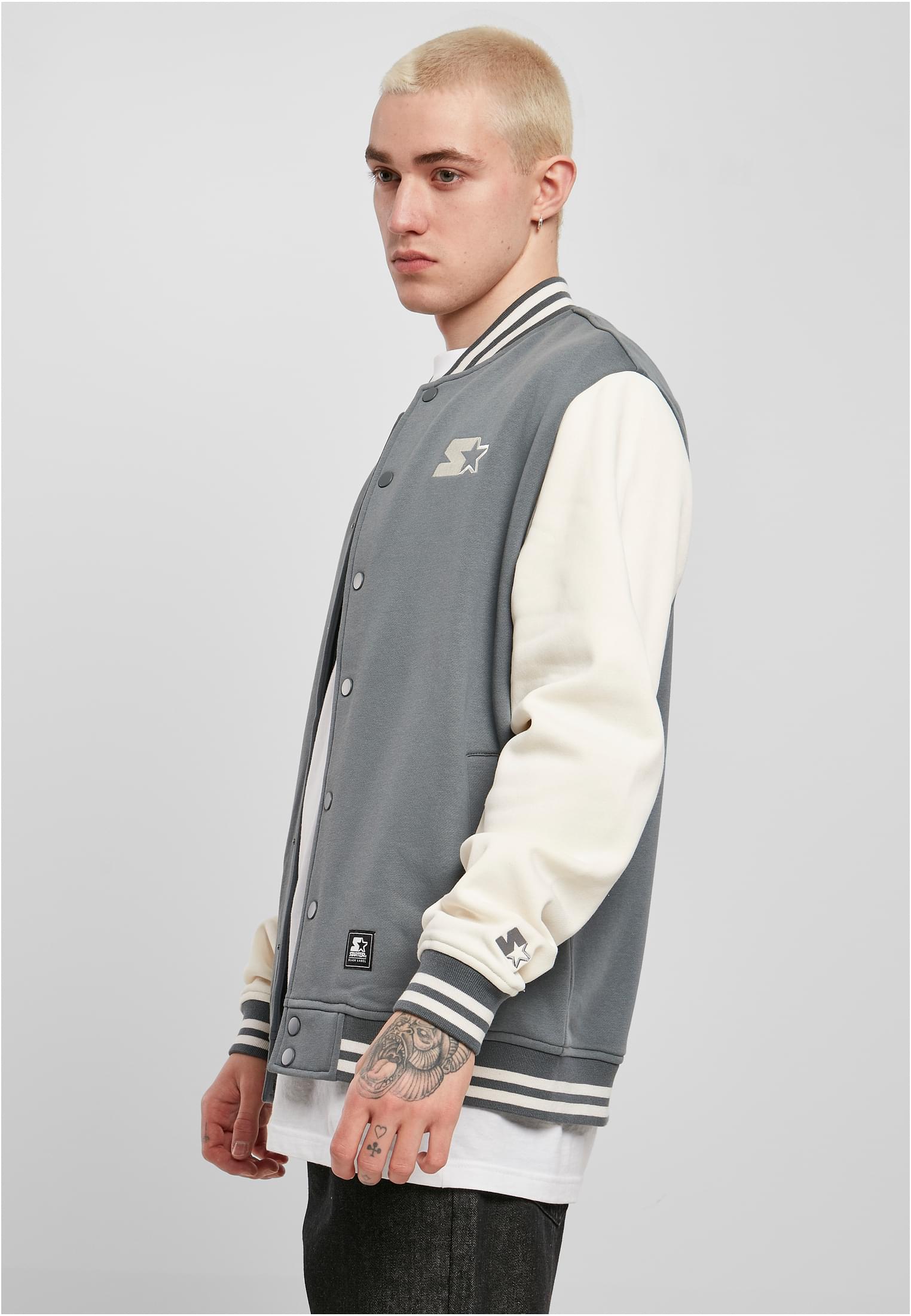 En man visar upp en grå SBL Starter College Fleece Jacket med vita ärmar, sedd från sidan.