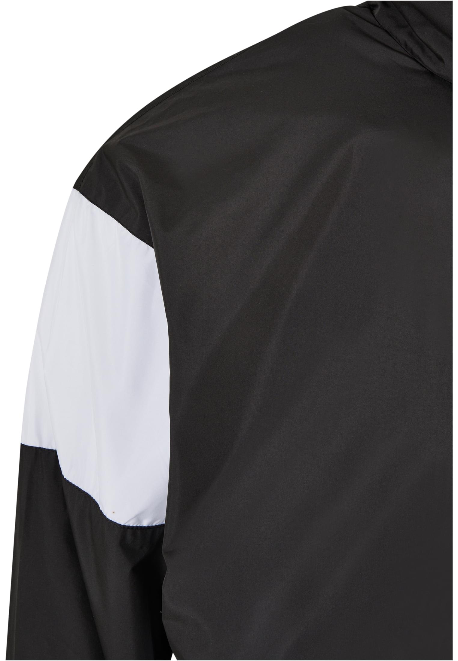 Detaljbild av SBL Retro Track Jacket, som visar axelpartiet med dess svarta och vita färgblock.