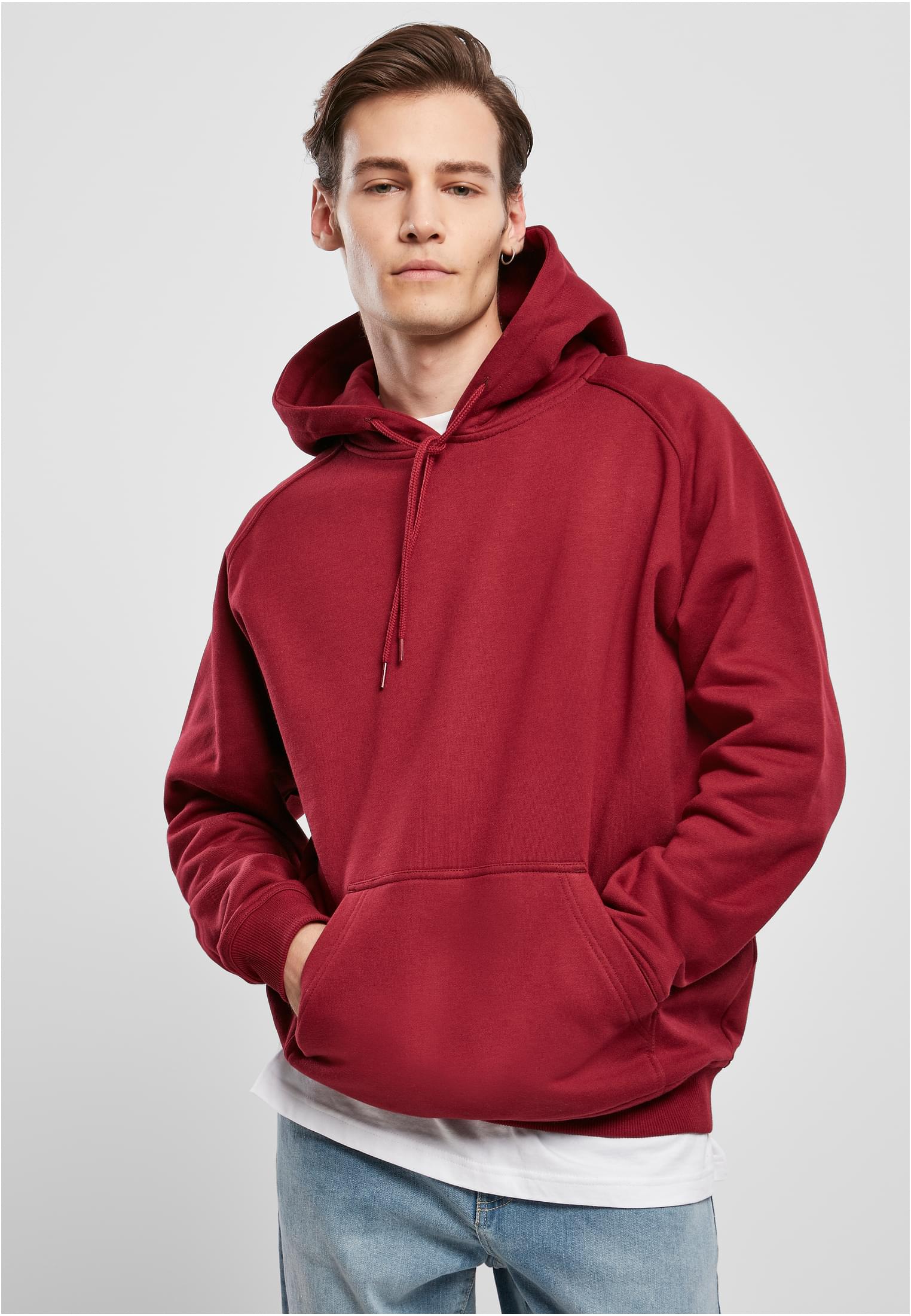 Manlig modell som bär en Blank Hoody från Urban Classics med händerna i framfickan.