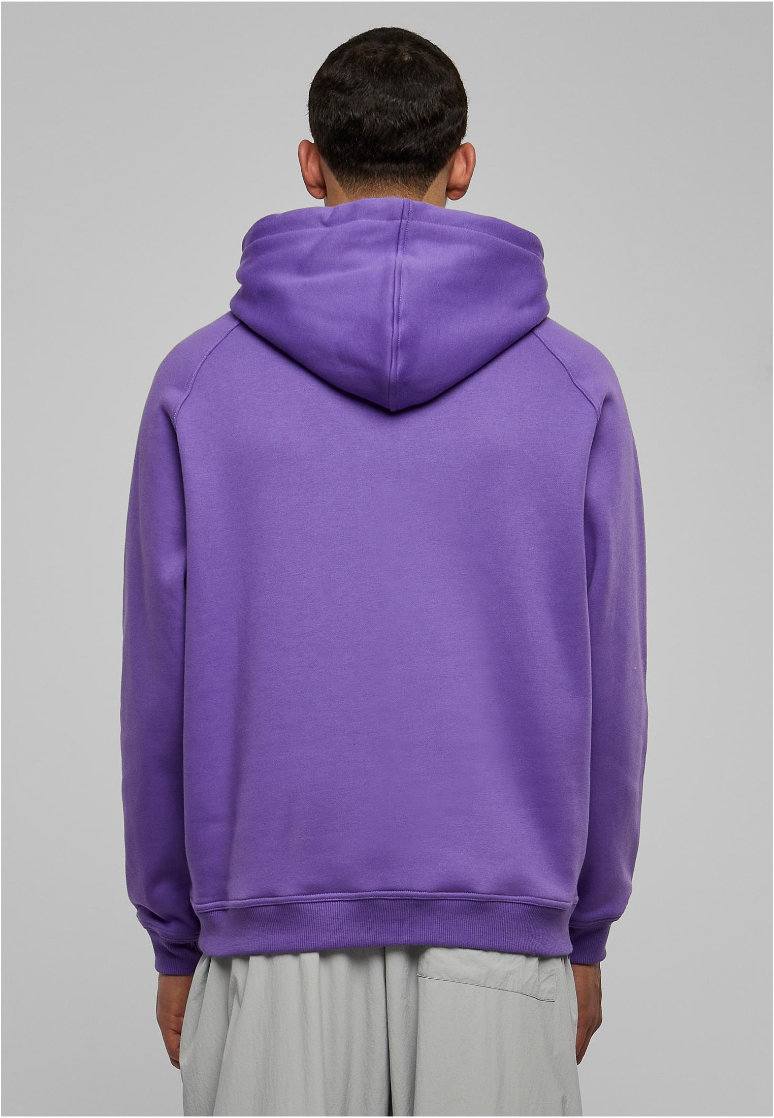Ryggvy av en man som bär en lila UC Blank Hoody.