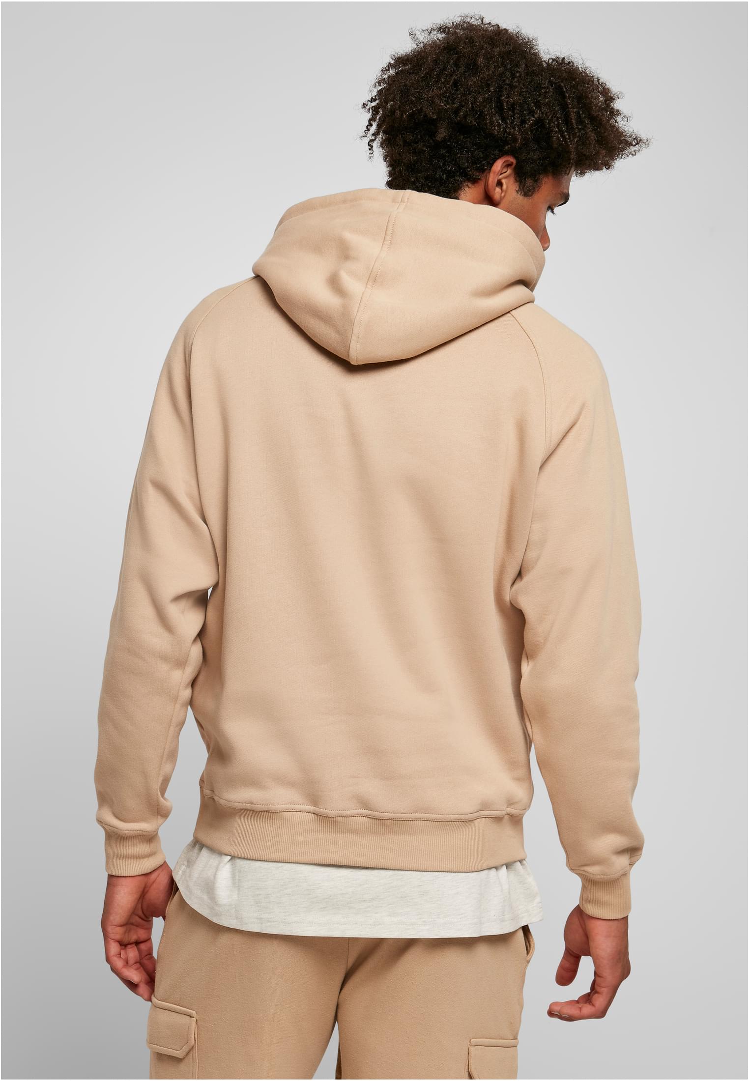 Man sedd bakifrån som bär en beige UC Blank Hoody.