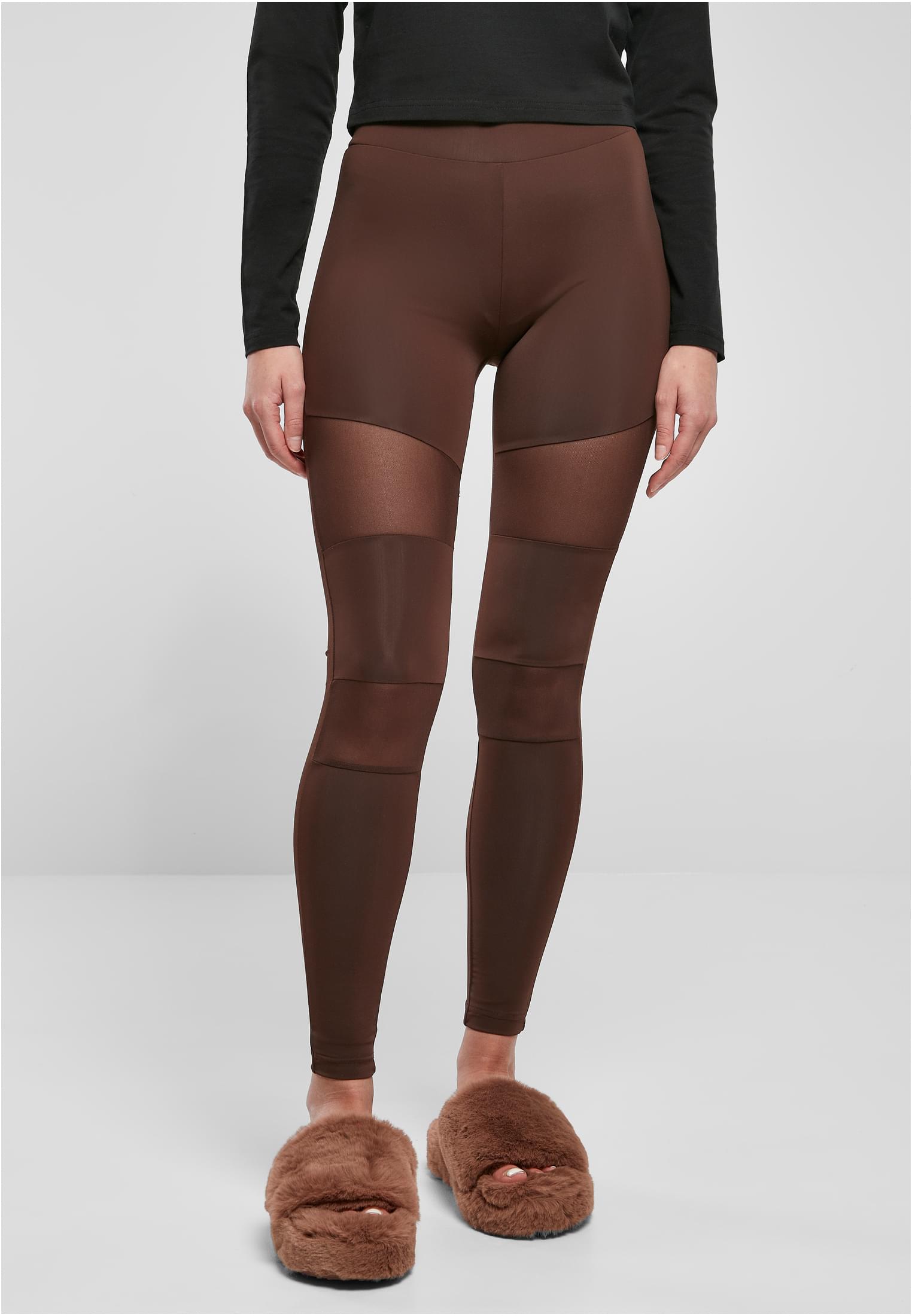 En kvinna som bär de varmgrå Ladies Tech Mesh Leggings, som visar upp de genomskinliga meshpanelerna på framsidan av benen.