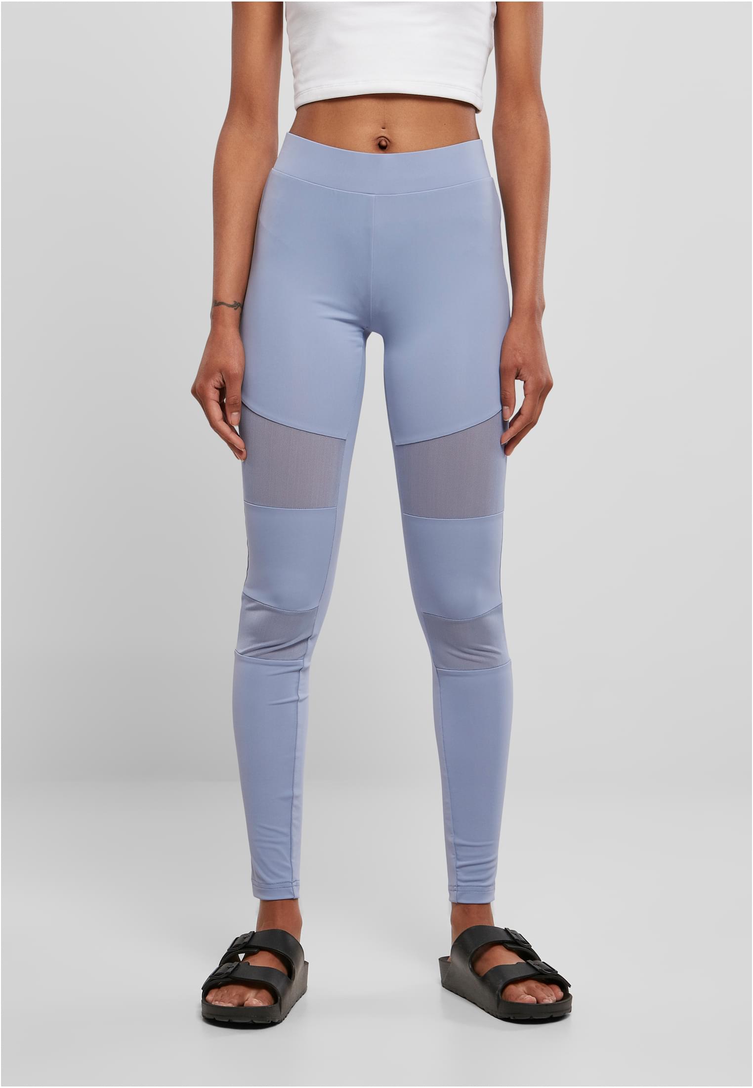 En kvinna sedd framifrån, klädd i ett par ljusgrå Ladies Tech Mesh Leggings med nätpaneler på låren.