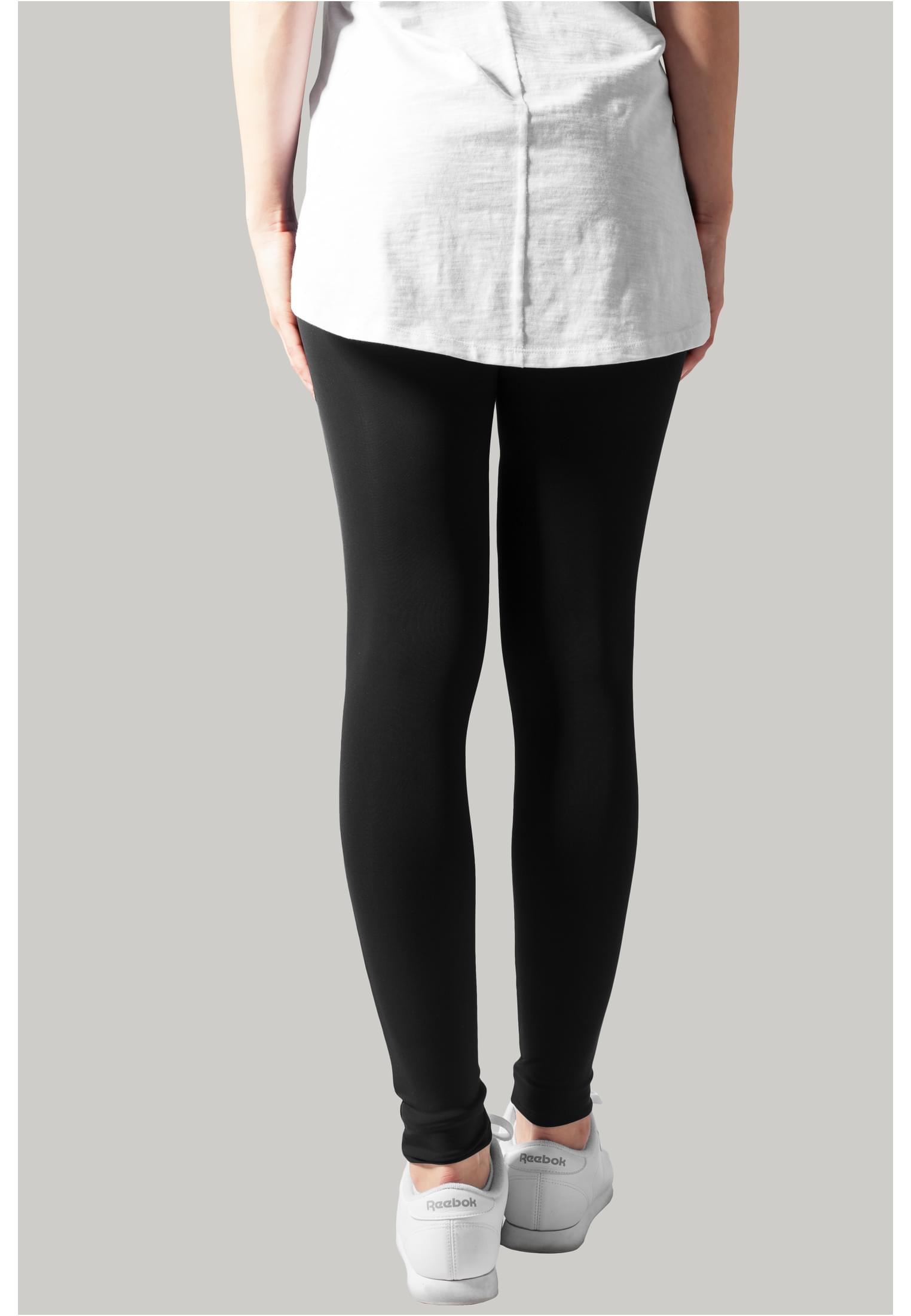 Baksidan av en modell som bär svarta Ladies Tech Mesh Leggings med en vit t-shirt och vita sneakers.