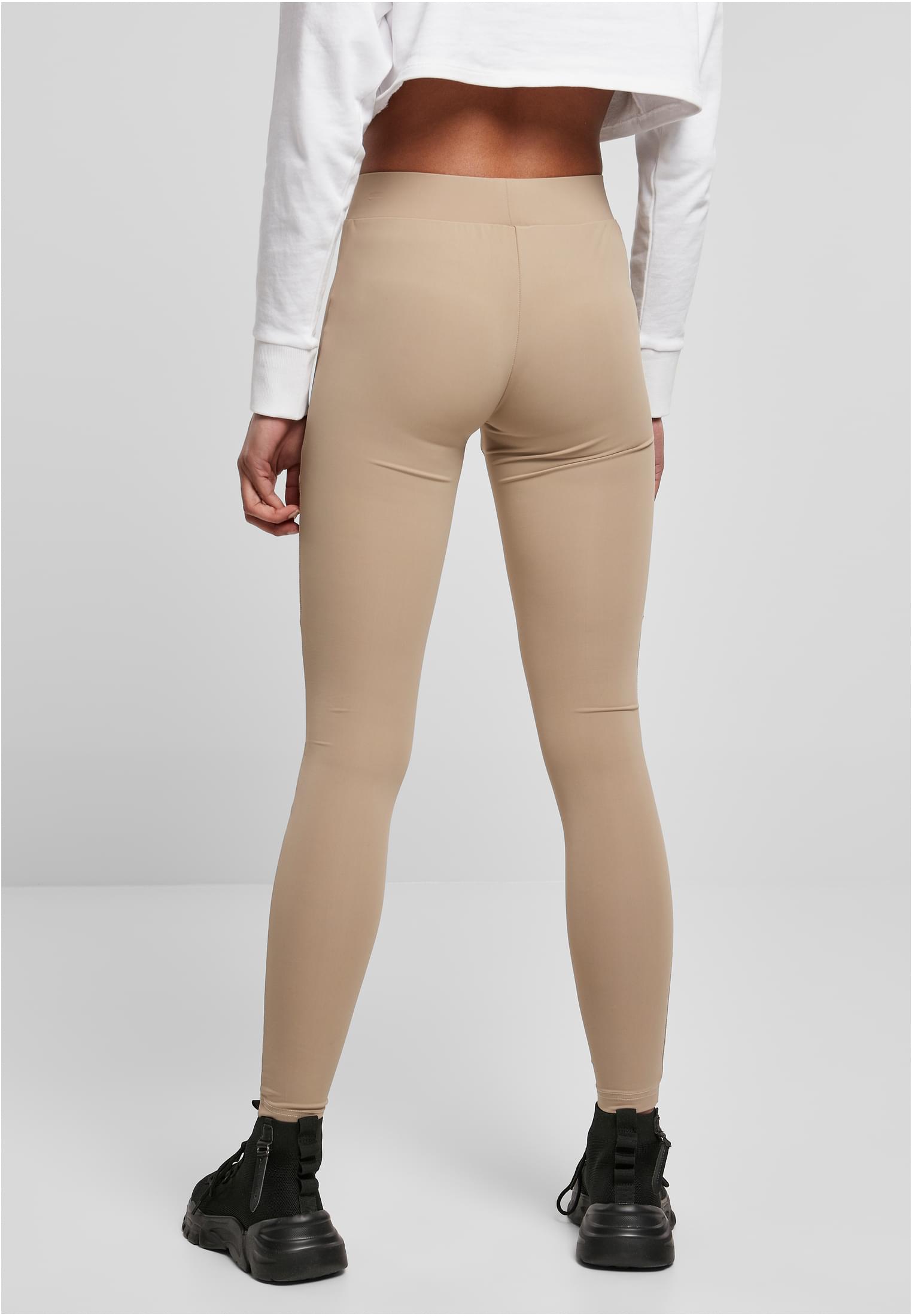 Vy bakifrån på en kvinna som bär varmgrå Ladies Tech Mesh Leggings, en vit croppad långärmad tröja och svarta sneakers.