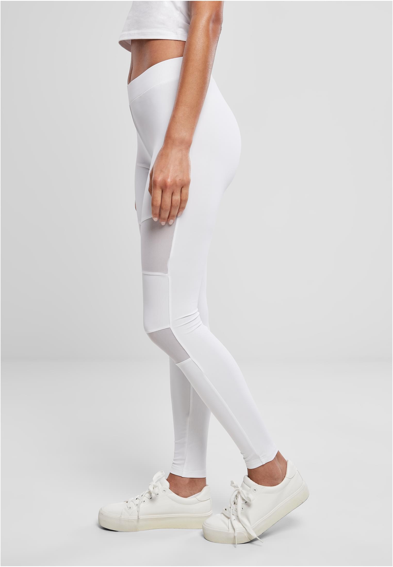 Kvinna sedd från sidan, klädd i ljusgrå Ladies Tech Mesh Leggings med nätpaneler på låren och smalbenen.