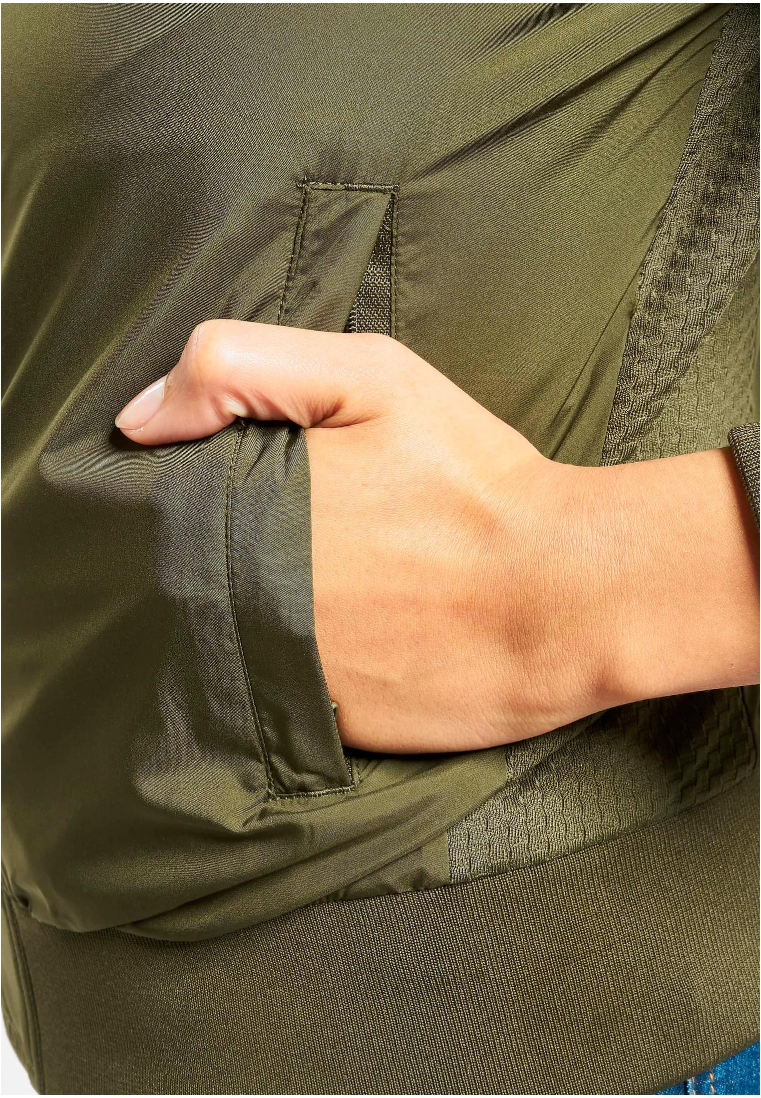 Närbild på en hand i fickan på en olivgrön bomberjacka.