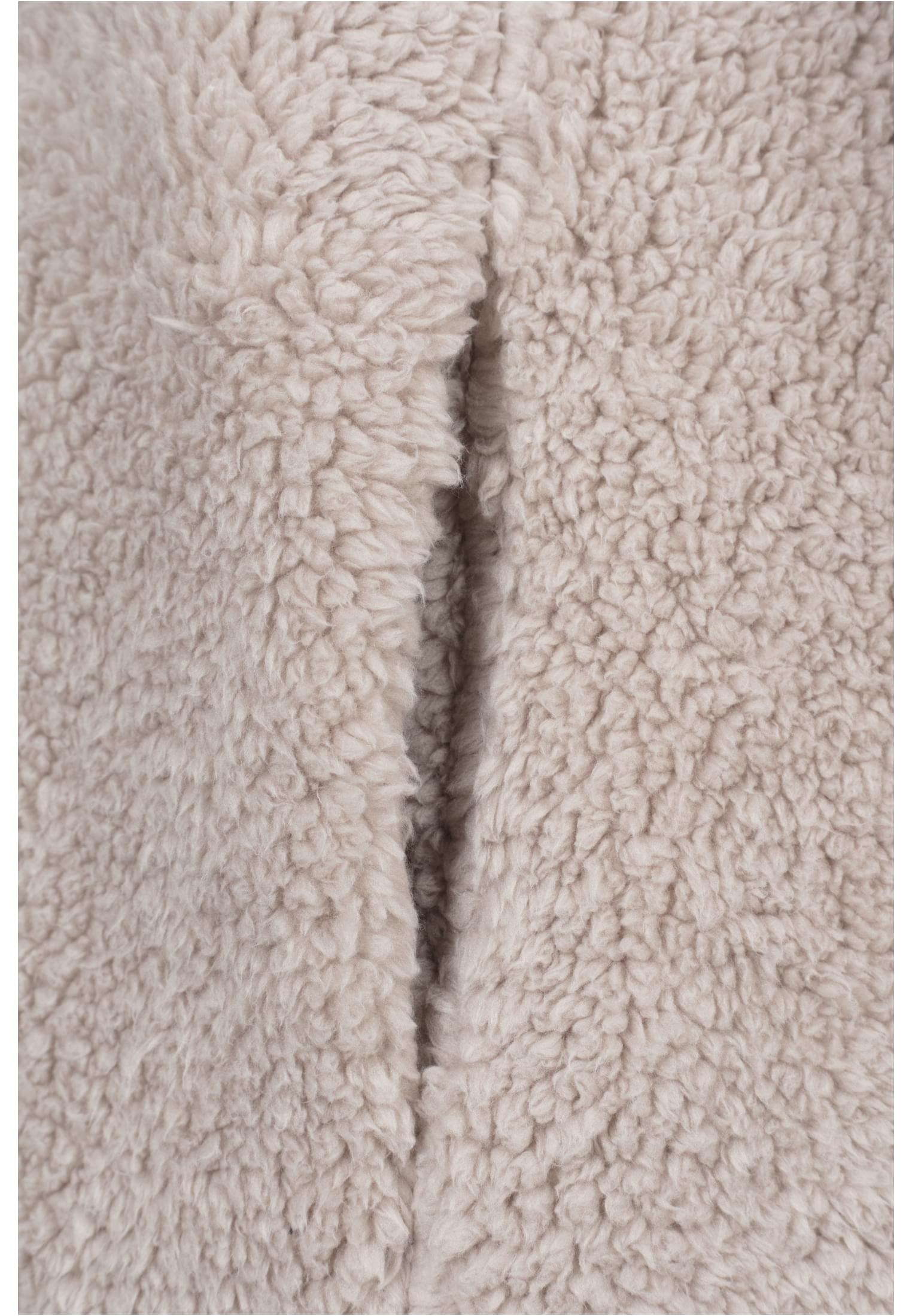 Närbild på det beigea, fluffiga sherpatyget på en UC Sherpa Jacket.