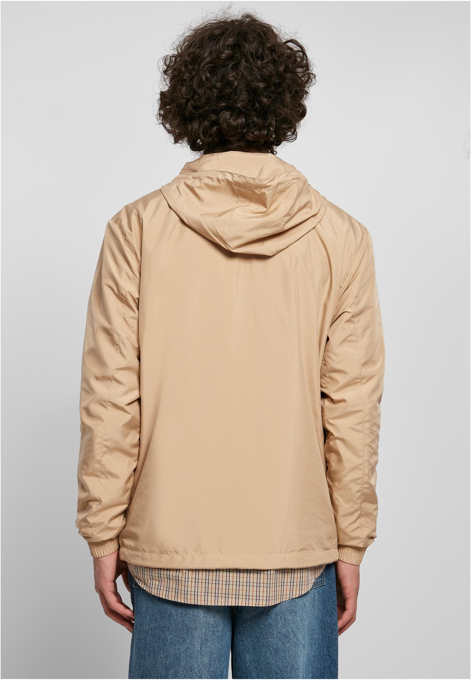 Baksidan av en man som bär en beige UC Basic Pull Over Jacket.