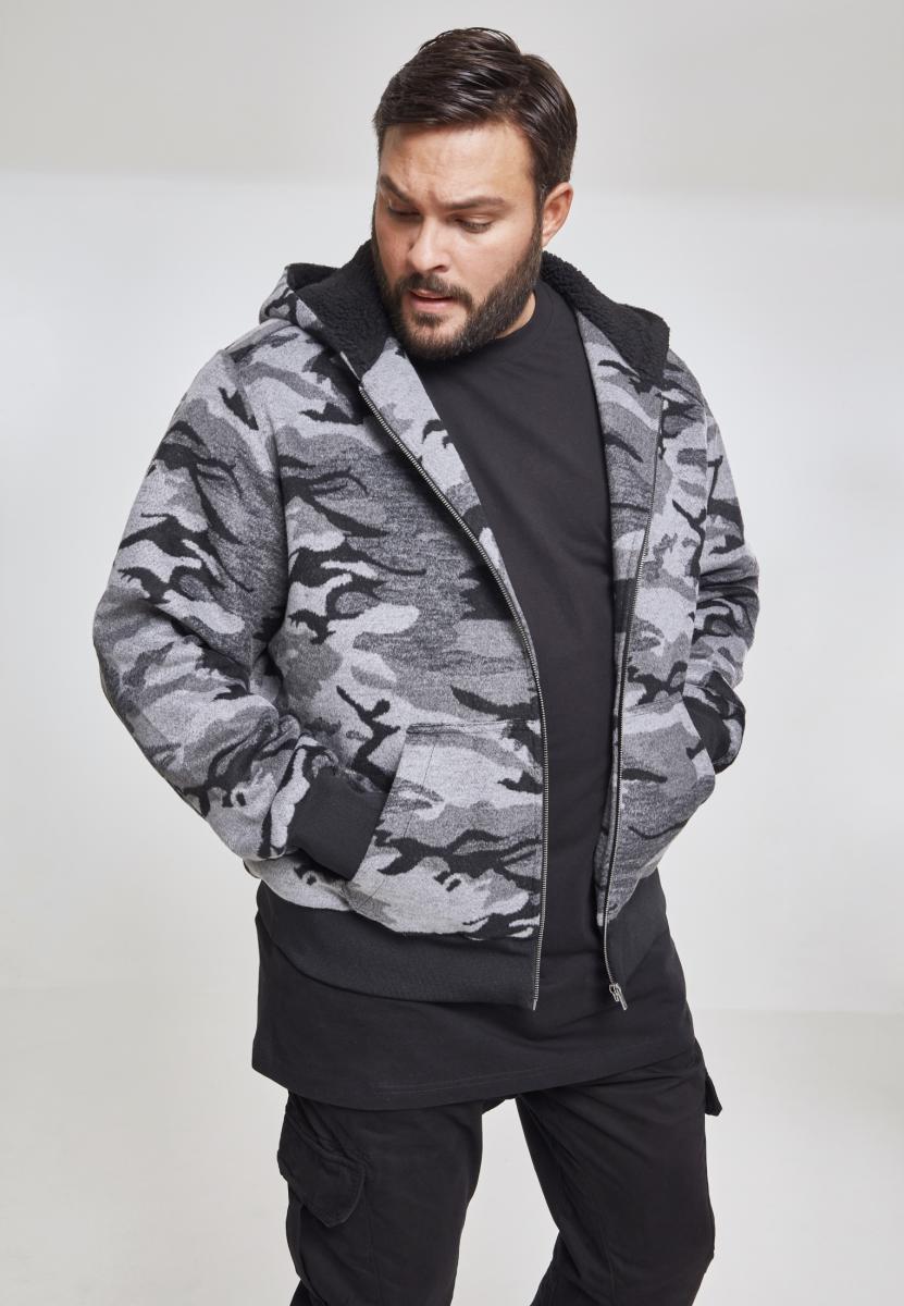 En manlig modell visar framsidan av UC Camo Zip Jacket i grått kamouflagemönster med händerna i fickorna.