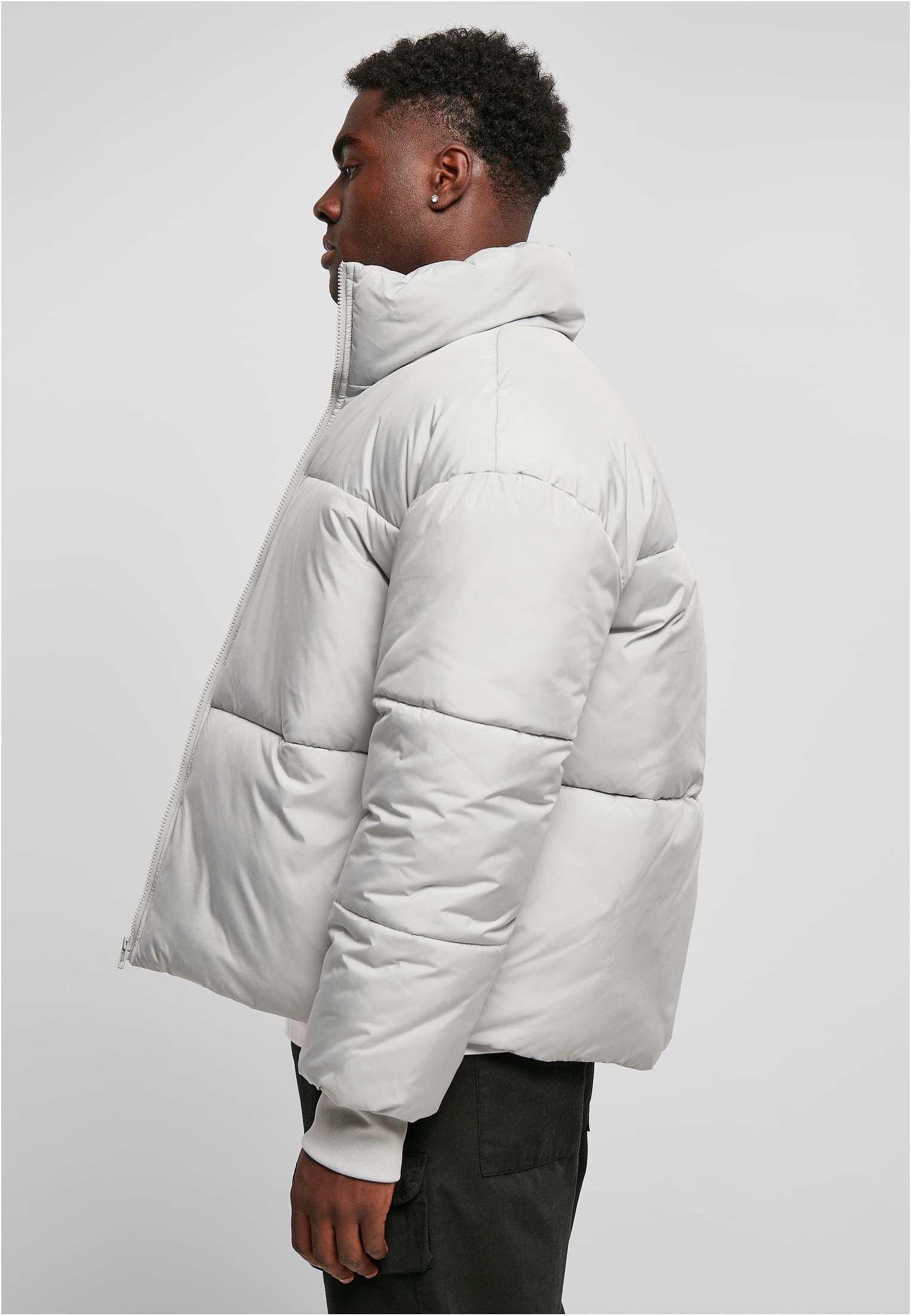 En man sedd från sidan som bär en ljusgrå UC Short Big Puffer Jacket.