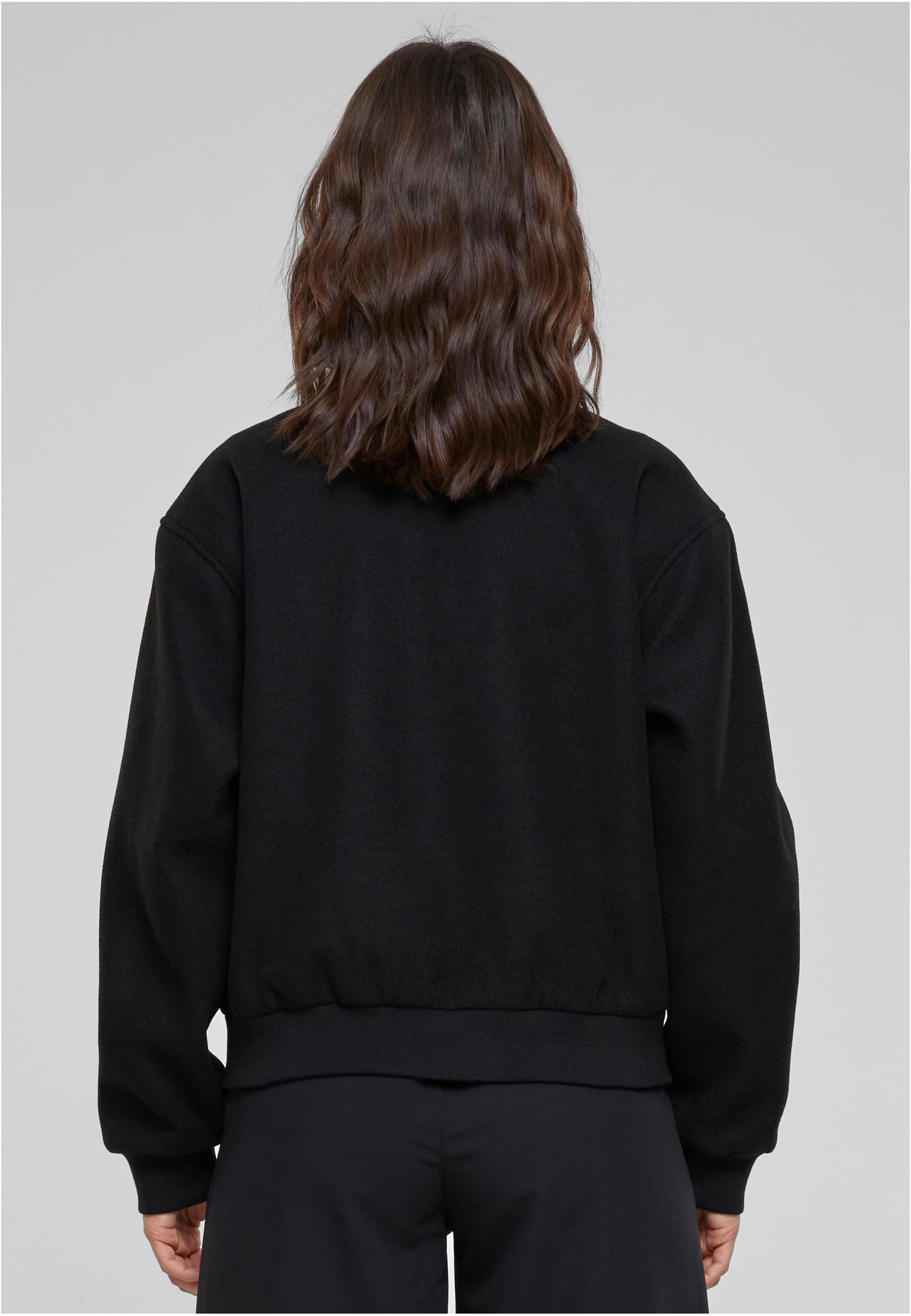 Baksidan av en kvinna som bär en svart jacka med boxig passform.