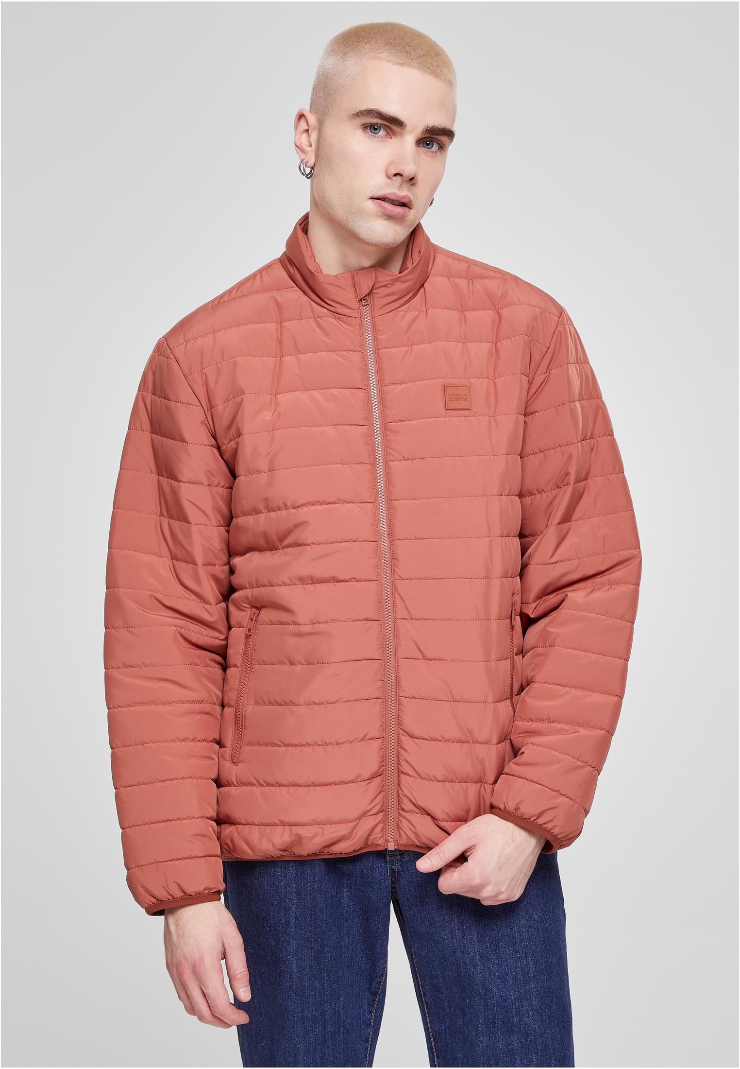 Frontvy av en man som bär en orange UC Light Bubble Jacket.