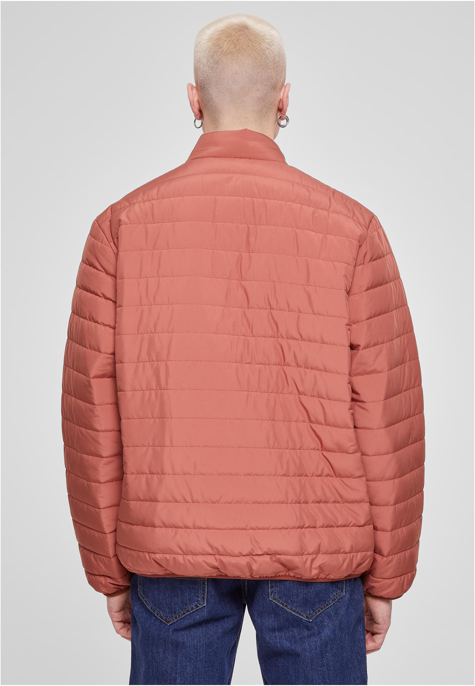 Baksidan av en man som bär en orange UC Light Bubble Jacket.