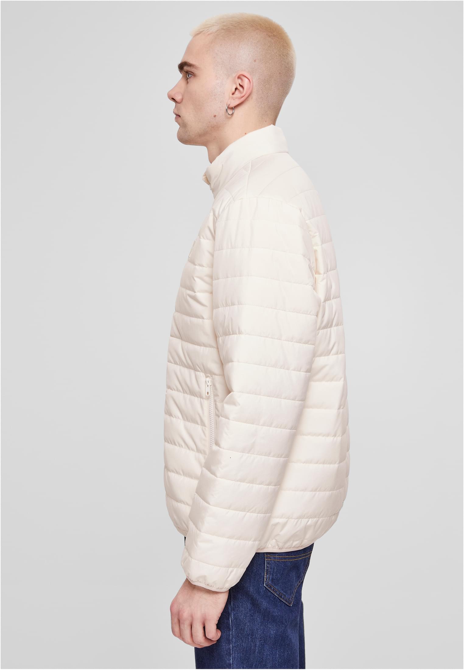 En manlig modell visar sidan av den beiga UC Light Bubble Jacket.