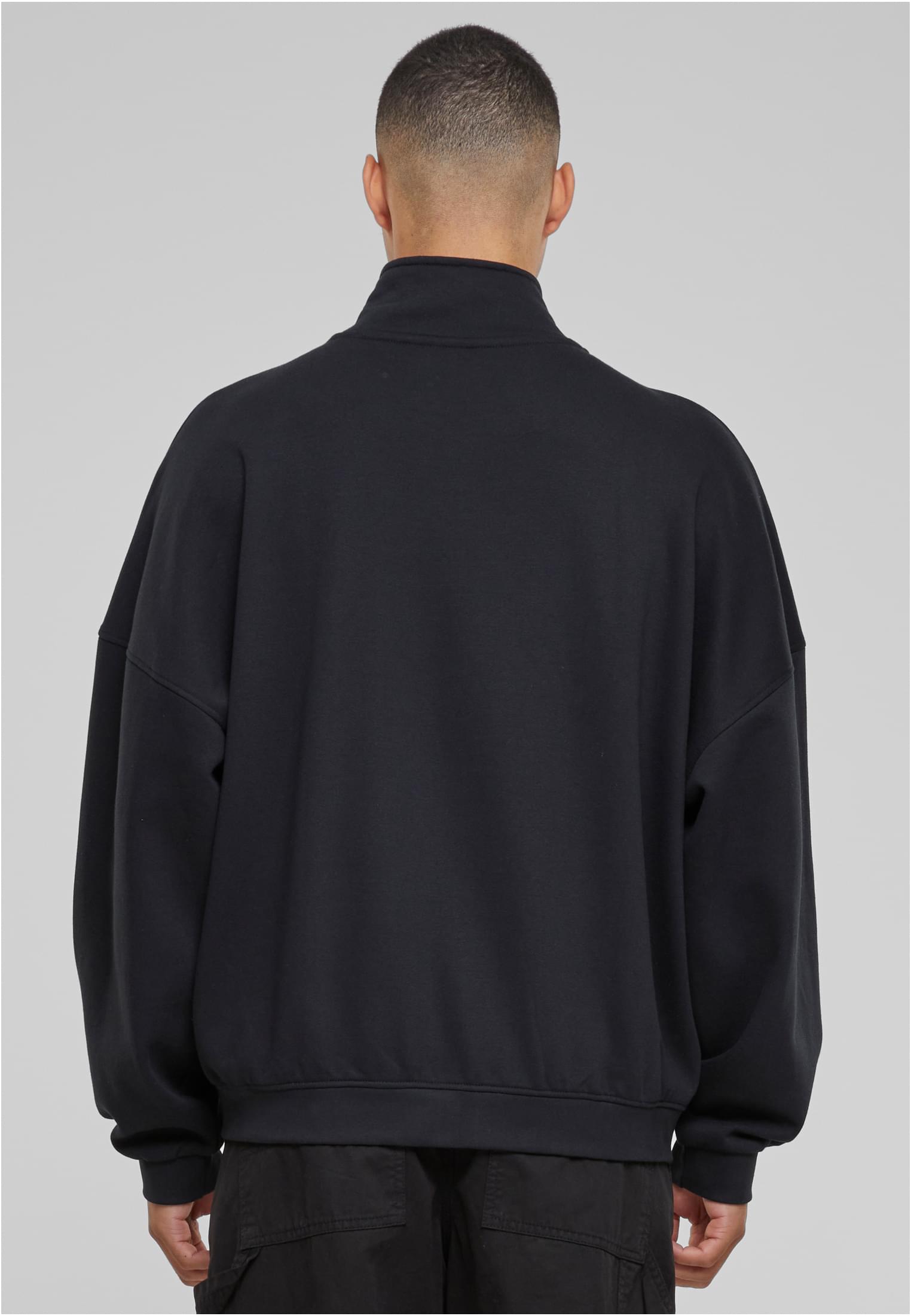 Baksidan av en man som bär en svart oversized UC 90s Track Jacket.