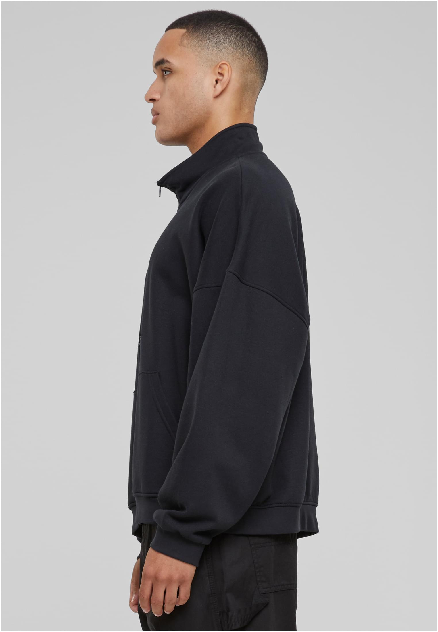 En man i sidoprofil som bär en svart UC 90s Track Jacket.