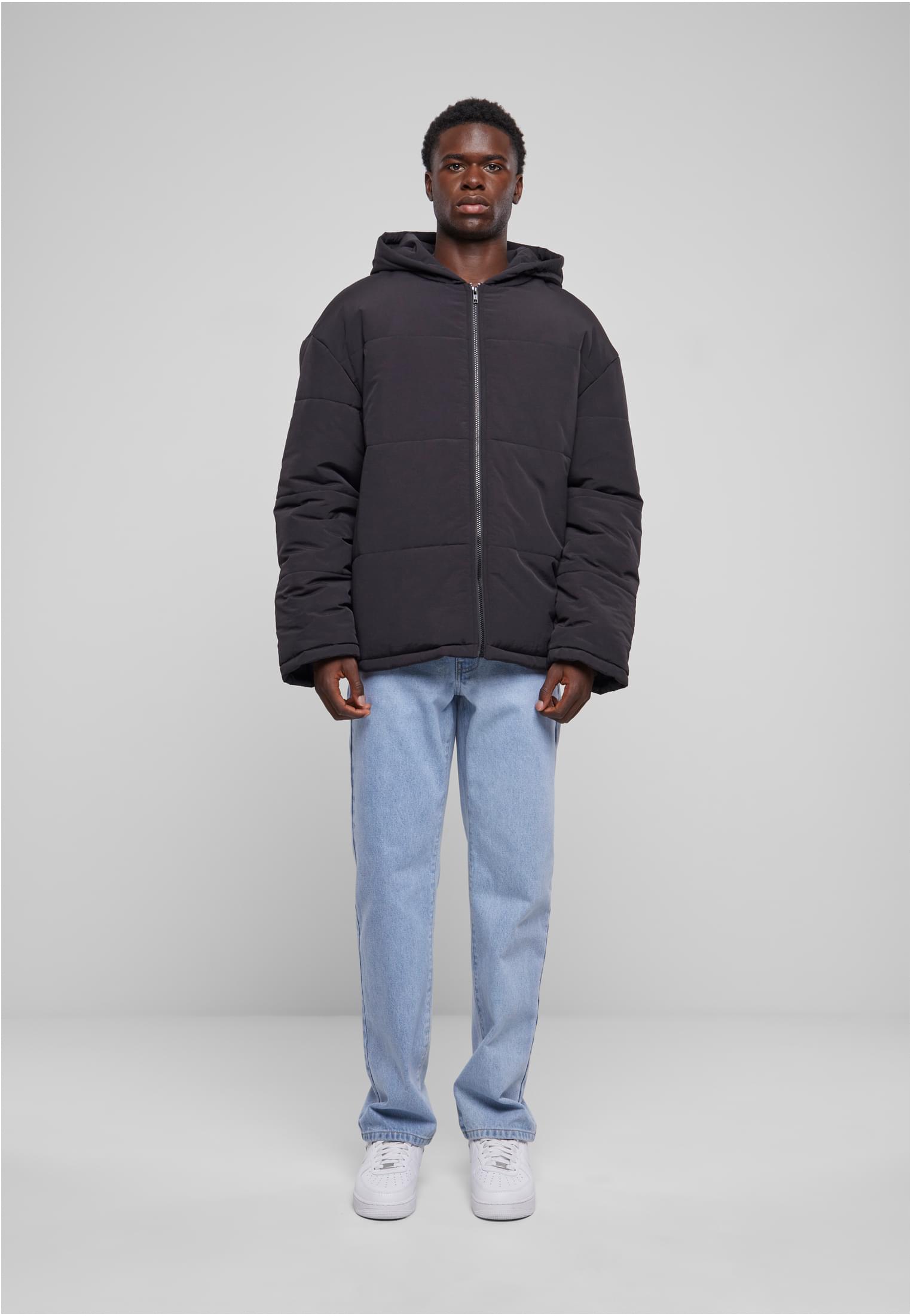 En man visar framsidan av den svarta jackan UC Hooded Block Puffer Jacket.