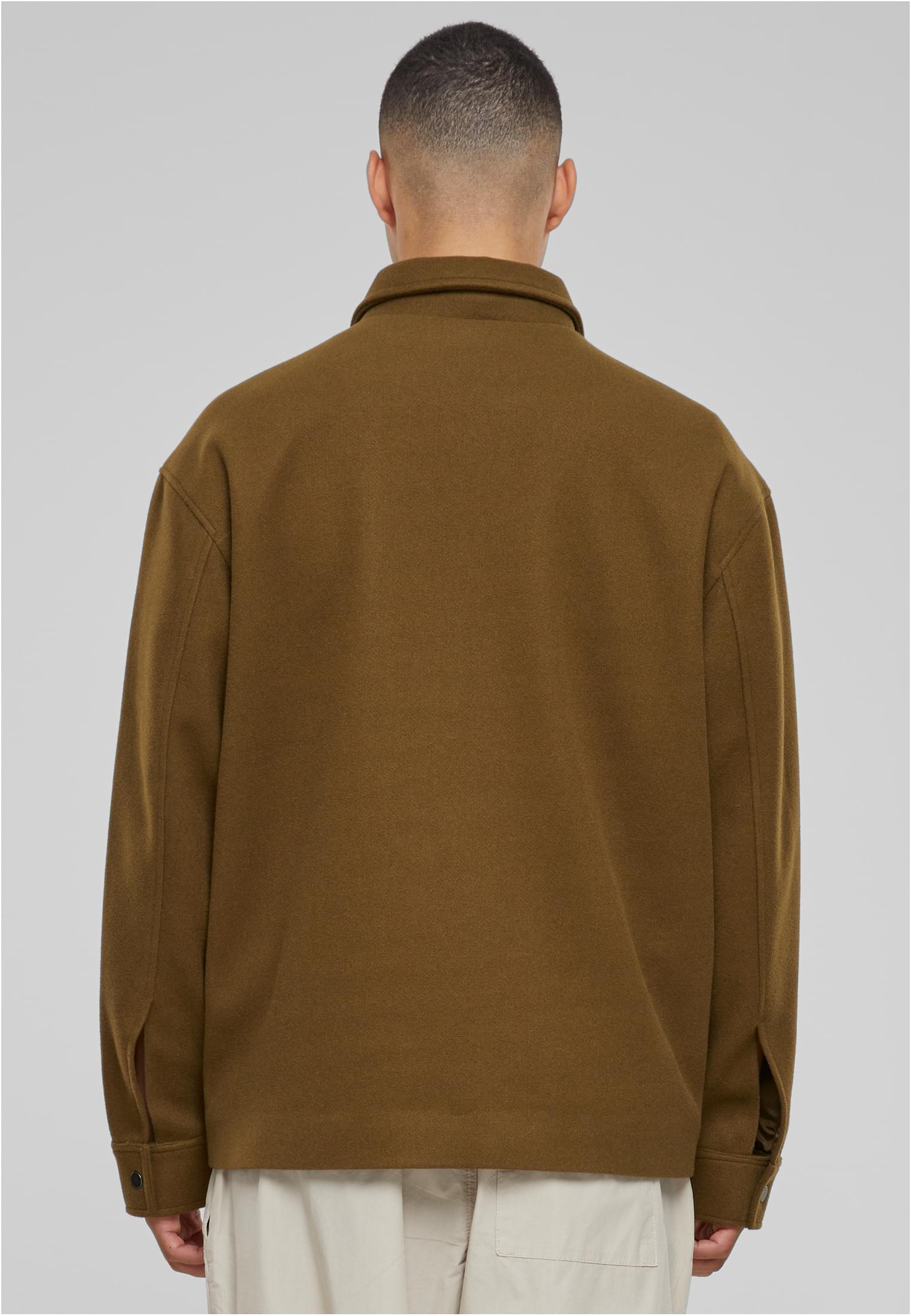 En man visar baksidan av en olivgrön UC Basic Blouson Jacket.