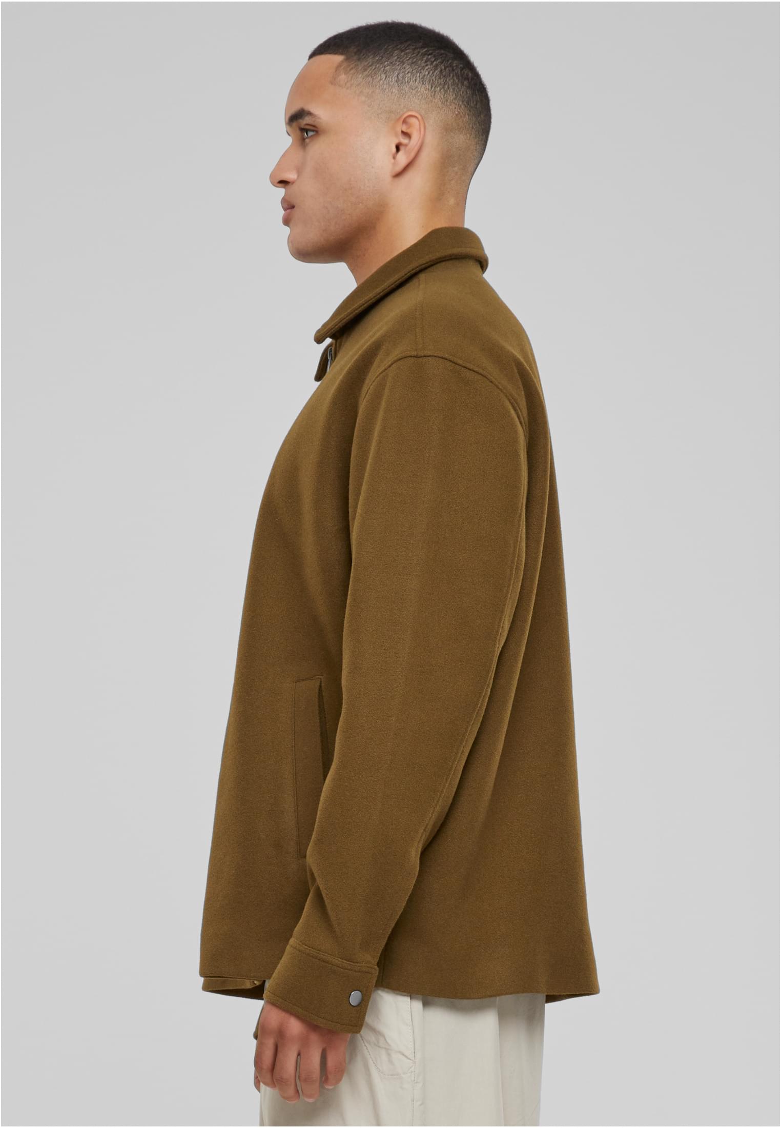 Sidovy av en man som bär den olivgröna UC Basic Blouson Jacket.