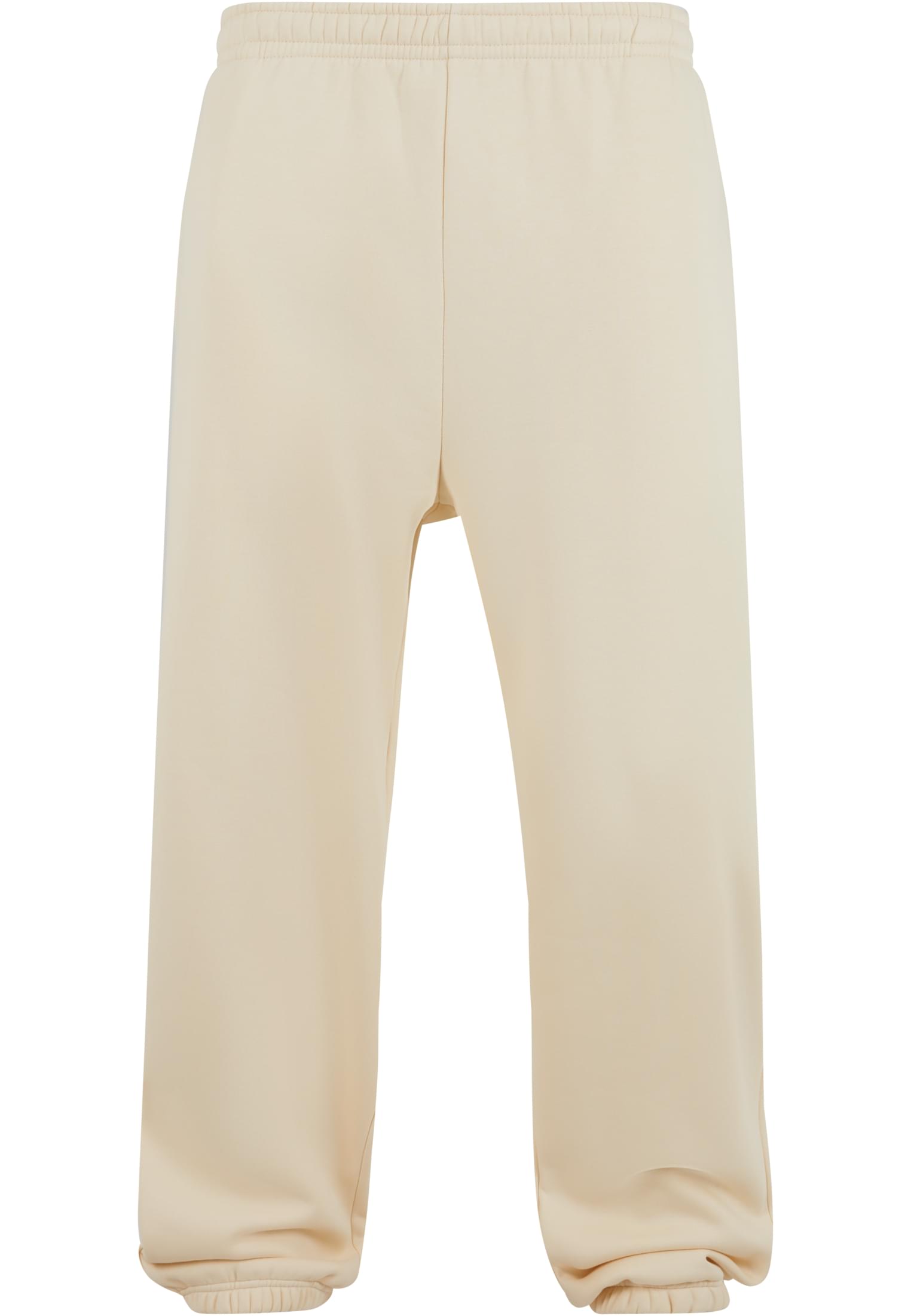 Ett par beiga mjukisbyxor med resår i midjan och bensluten, fotograferade mot en vit bakgrund.